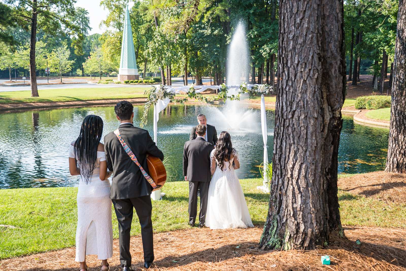 Couple exchanging vows under a tree beside the pond at First Baptist Atlanta
