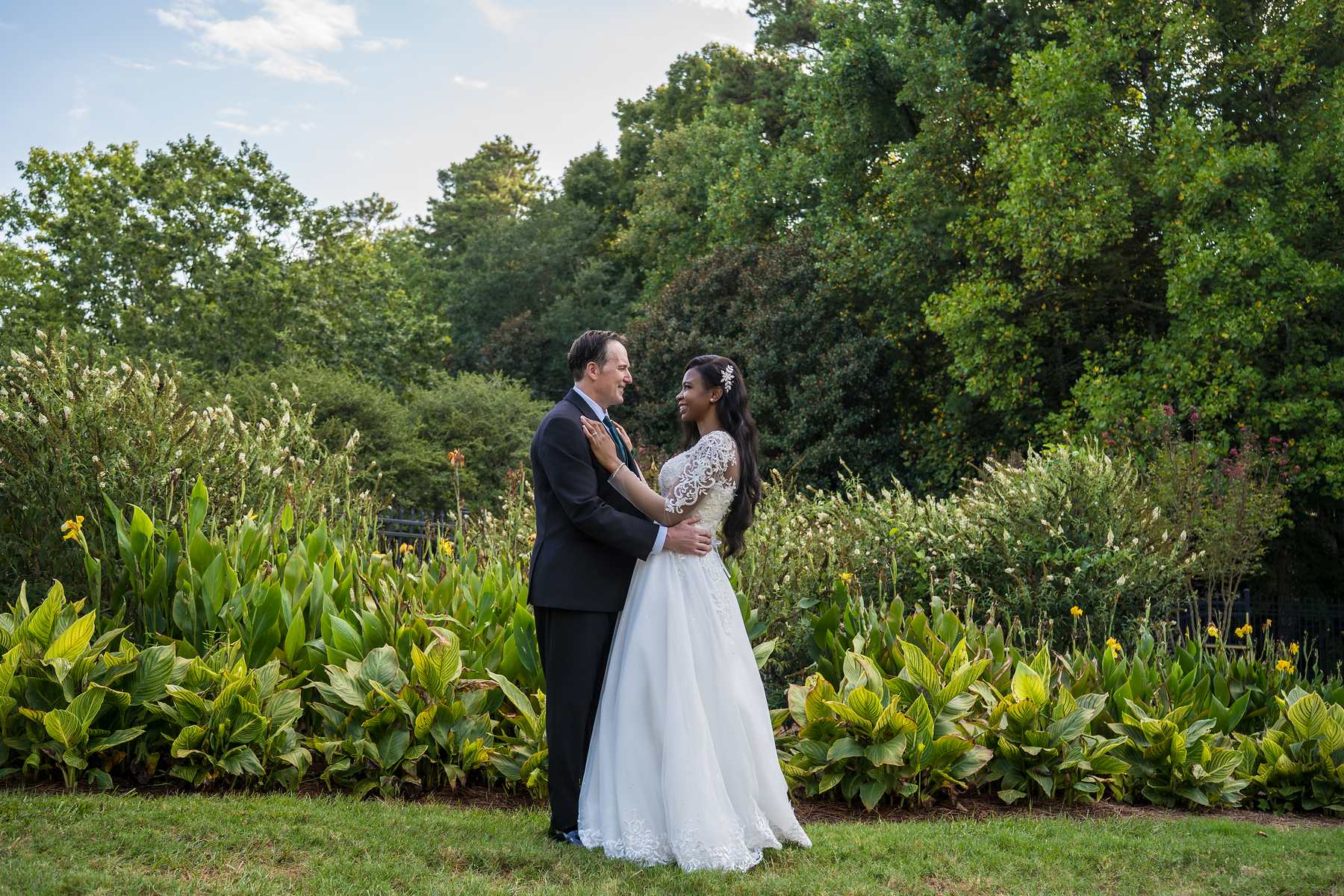 Couple embracing in front of a garden of green plants