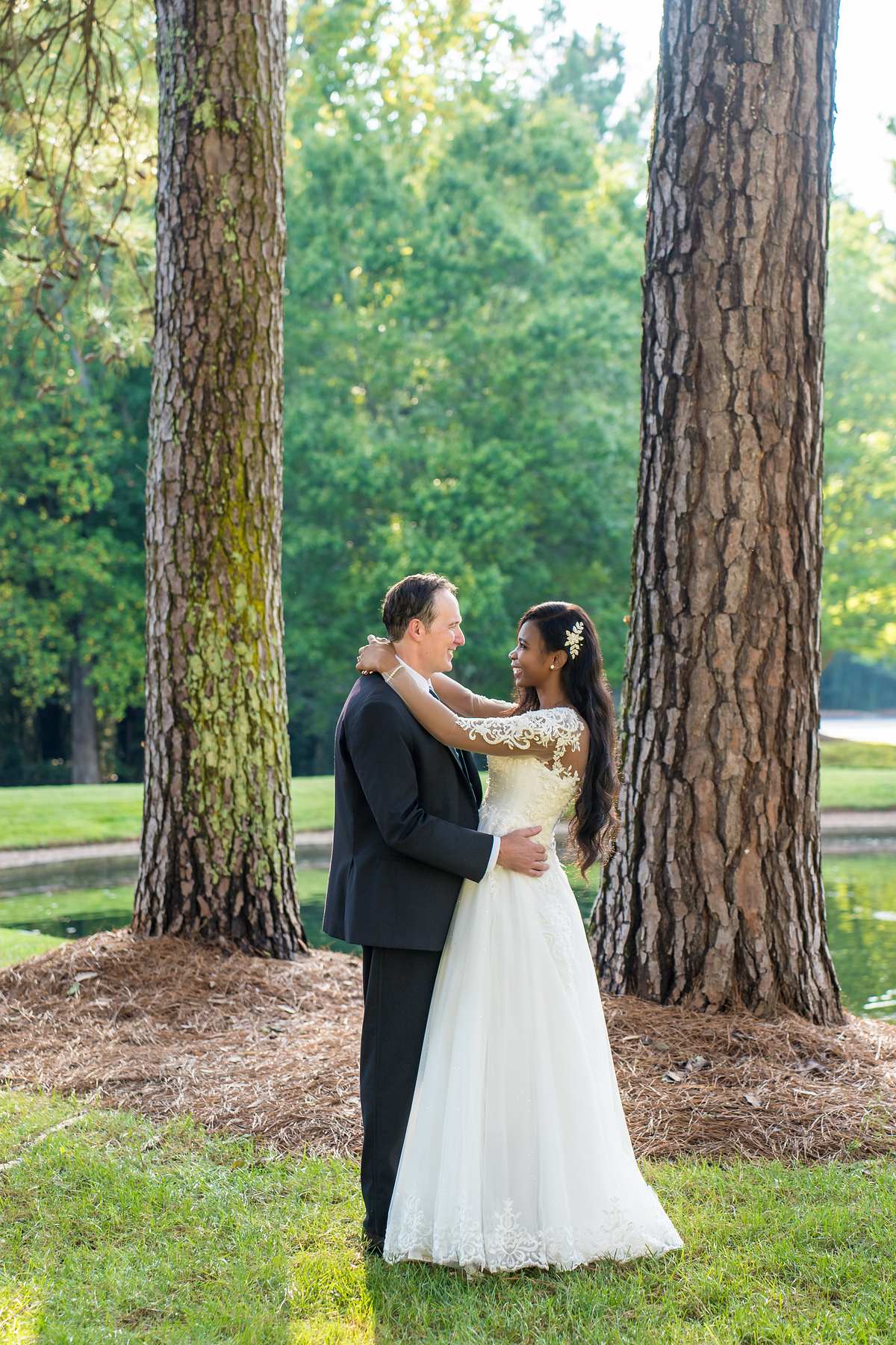 Couple portrait between tall pines on the church grounds