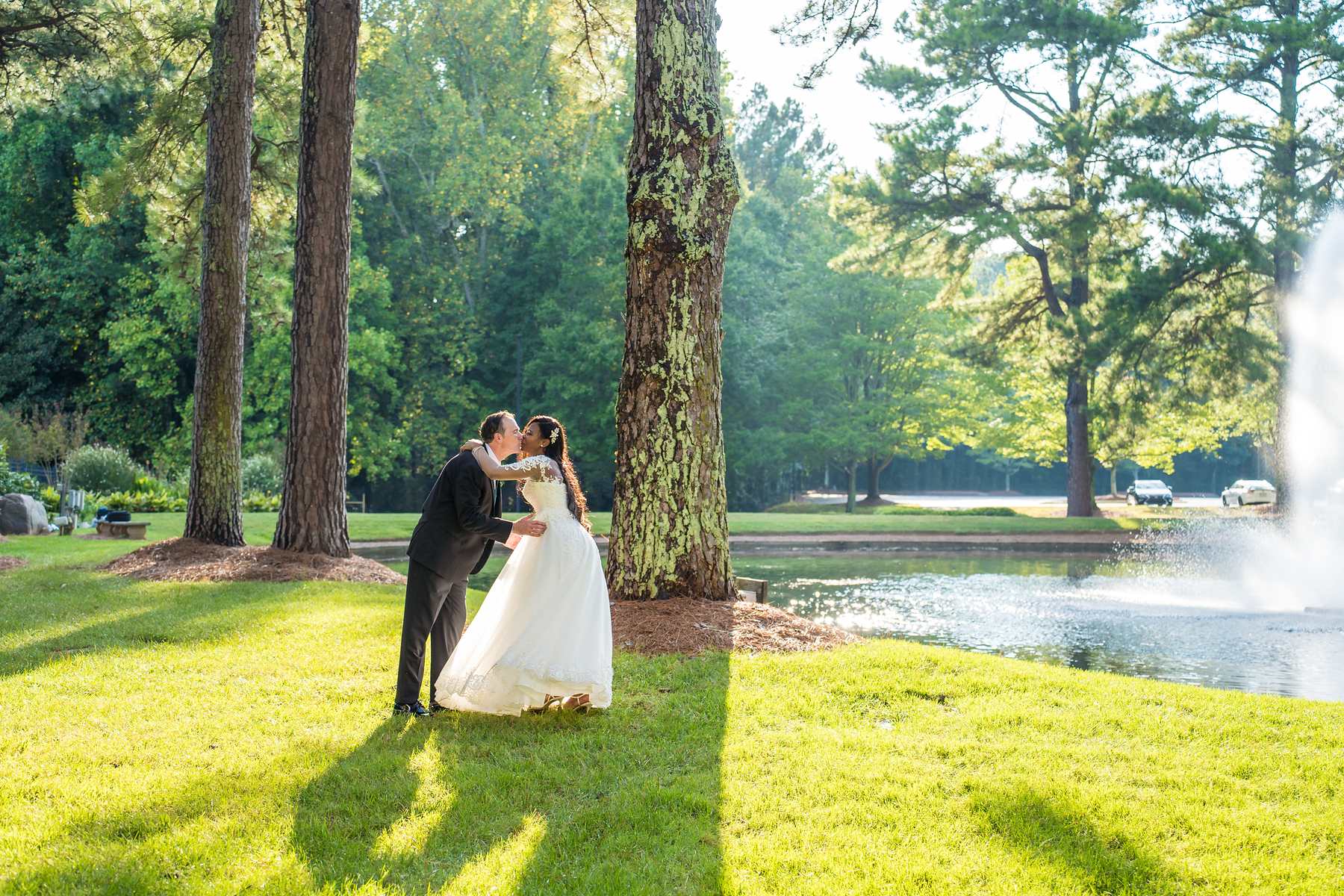 Couple kissing on the lawn in late afternoon light