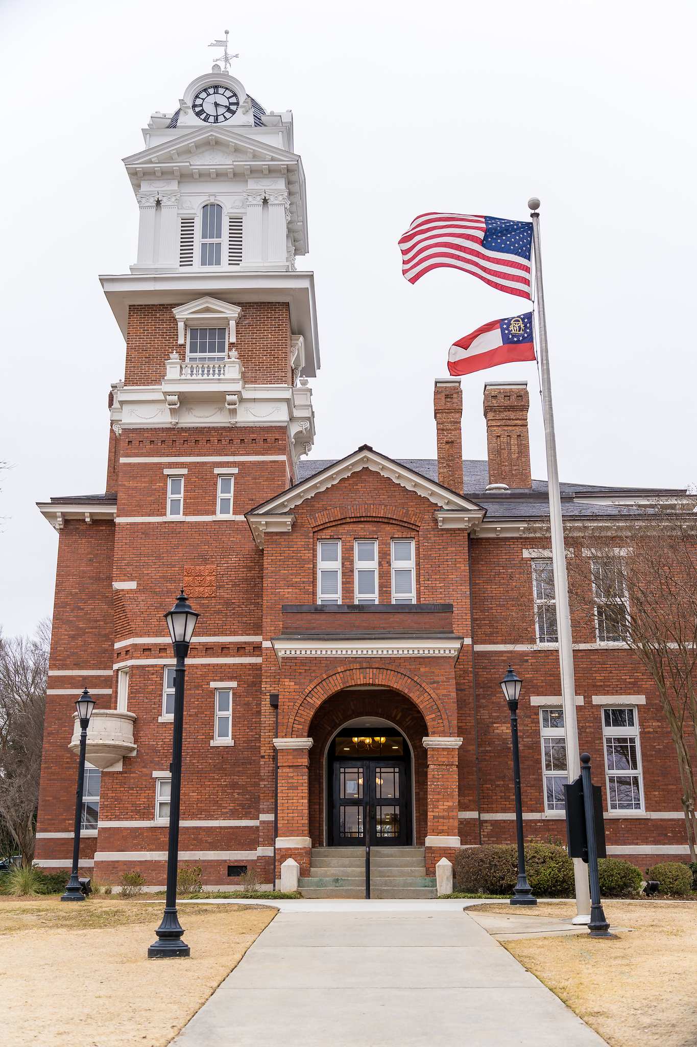 The Gwinnett Historic Courthouse clock tower and flags on a winter day