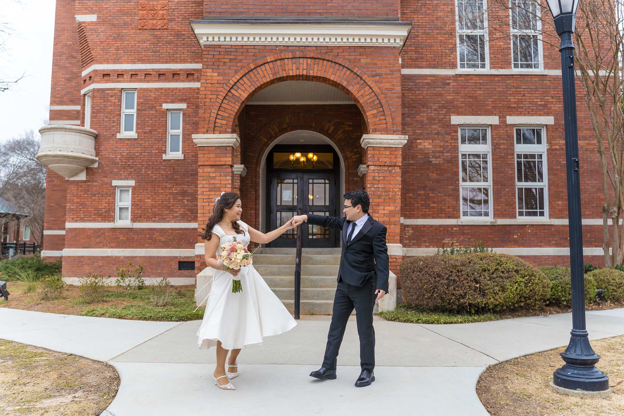 Bride and groom holding hands outside the Gwinnett Historic Courthouse entrance