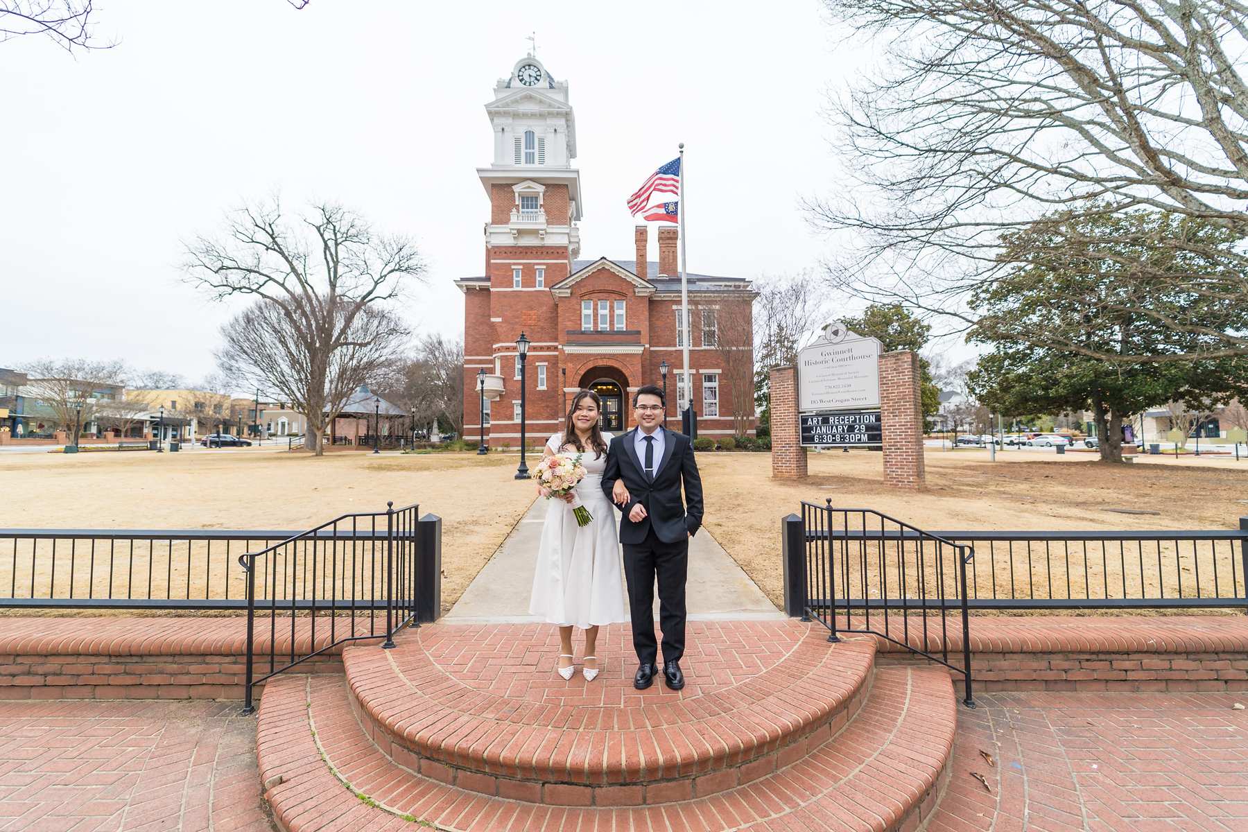 Couple standing on the brick steps in front of the Gwinnett Historic Courthouse