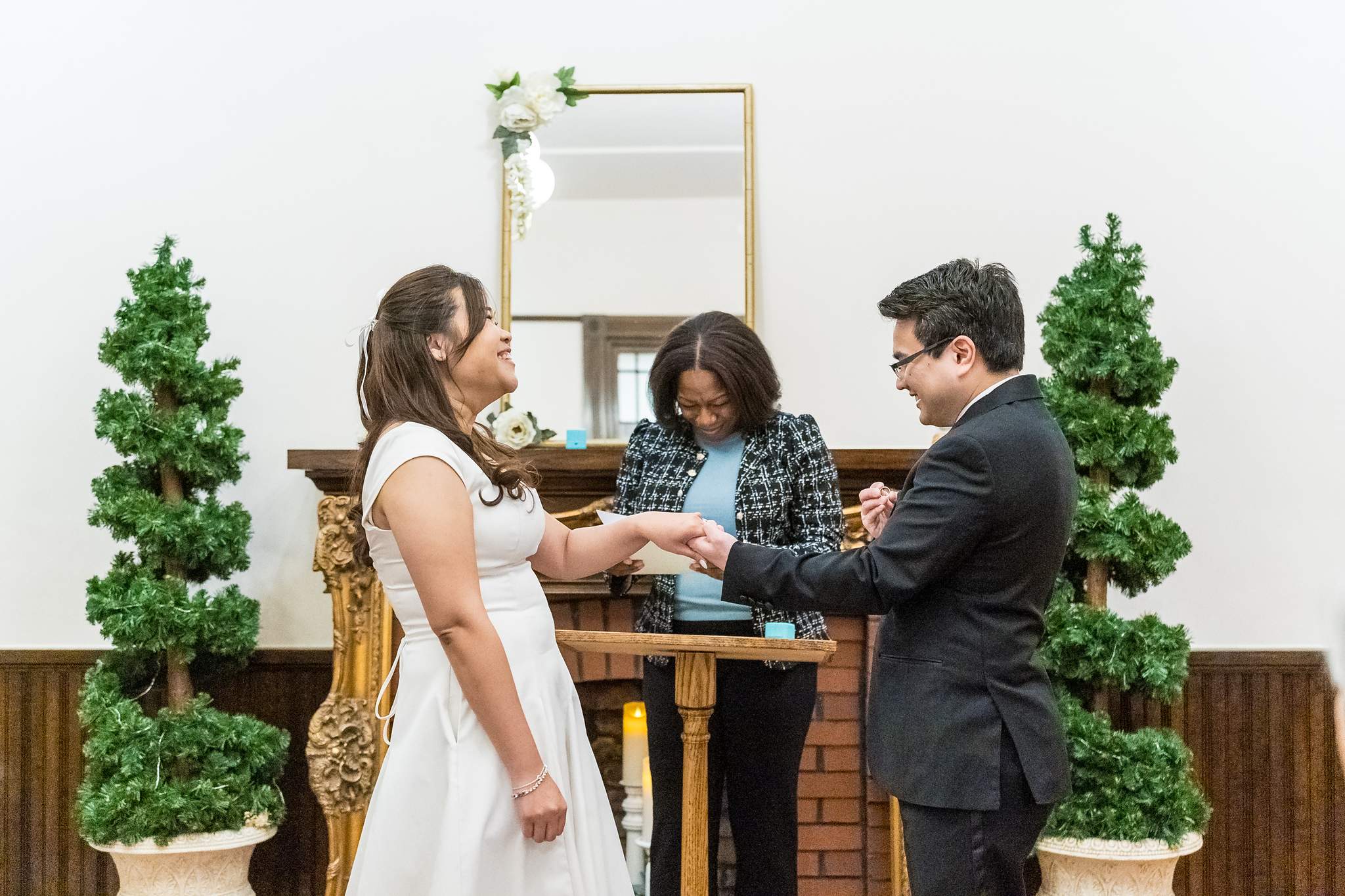 Couple exchanging rings in front of the officiant at the Gwinnett Historic Courthouse