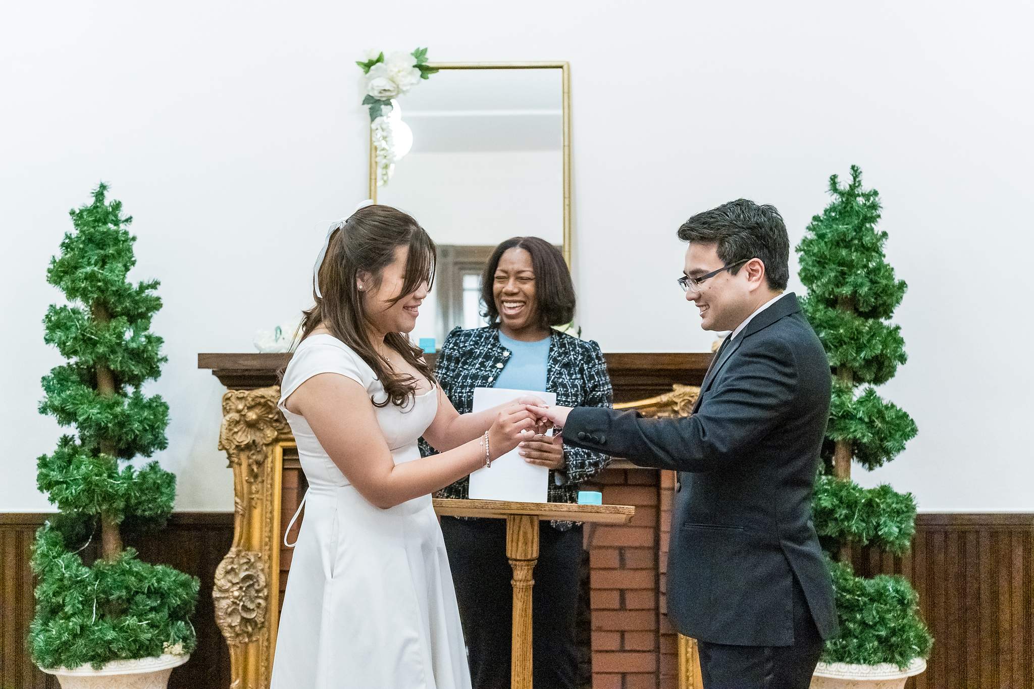 Couple holding hands with the officiant during a Gwinnett Historic Courthouse ceremony