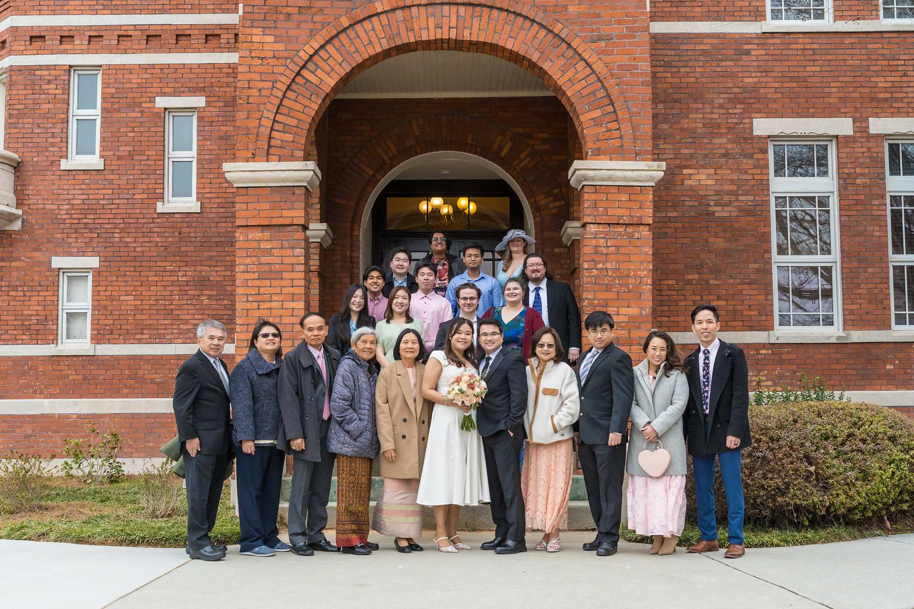 Large group photo of wedding guests at the arched front entrance of the Gwinnett Historic Courthouse