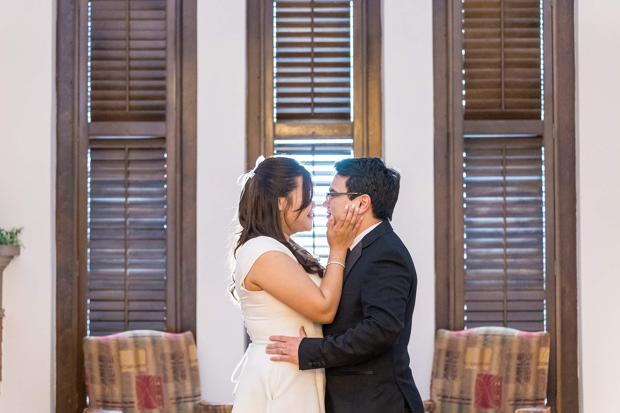 Couple portrait by the tall shuttered windows inside the Gwinnett Historic Courthouse
