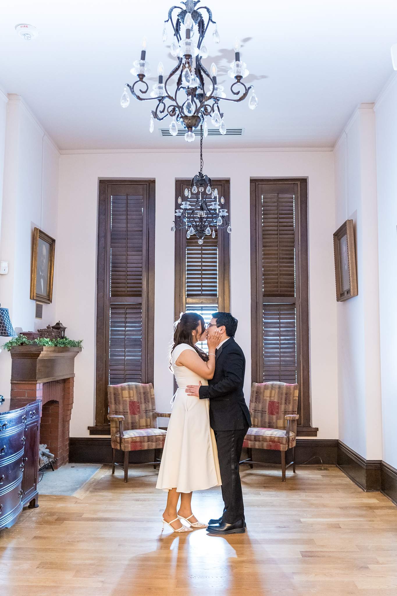 Couple under a chandelier in a hallway of the Gwinnett Historic Courthouse