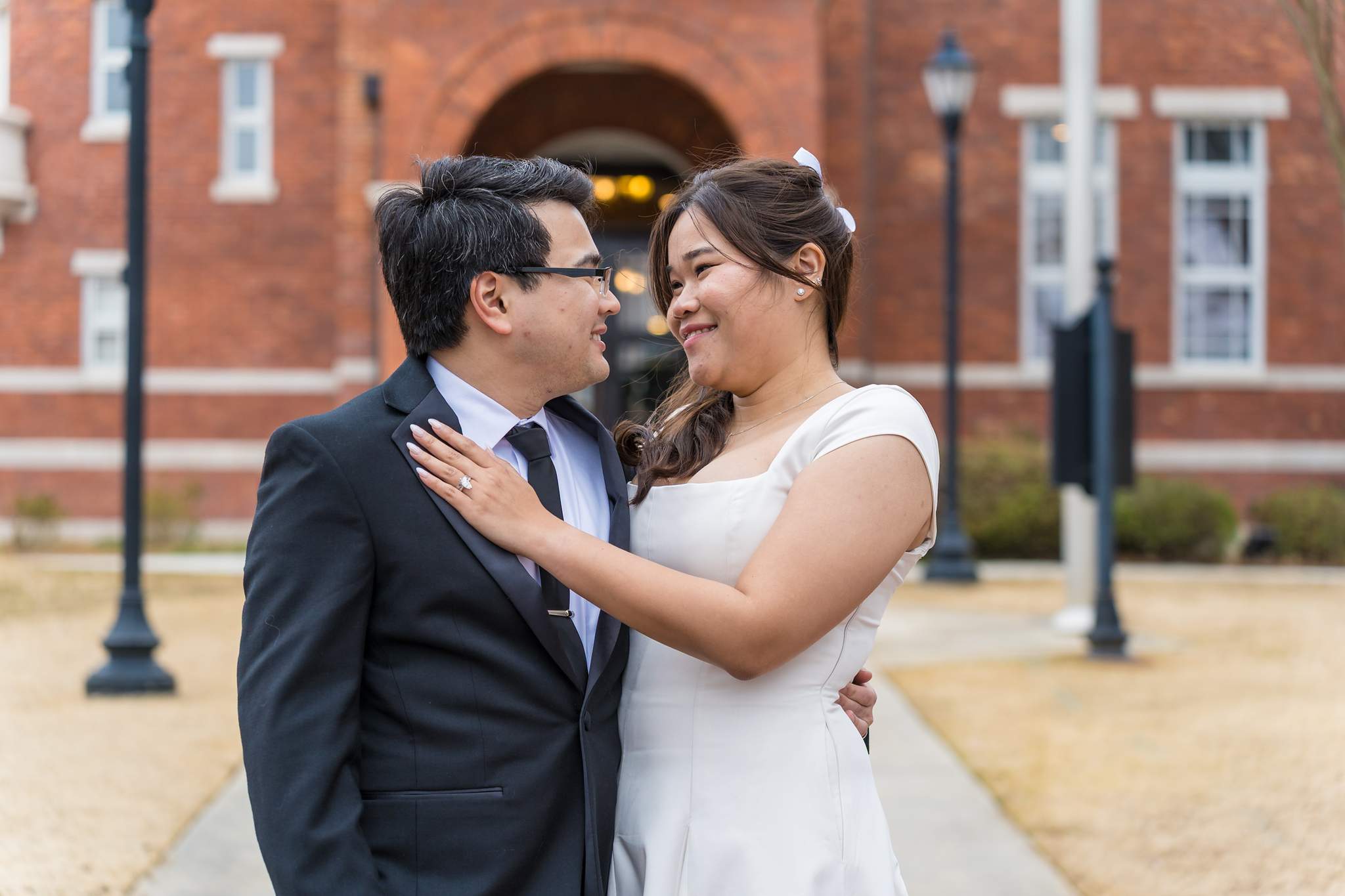 Couple embracing outside the Gwinnett Historic Courthouse after their wedding