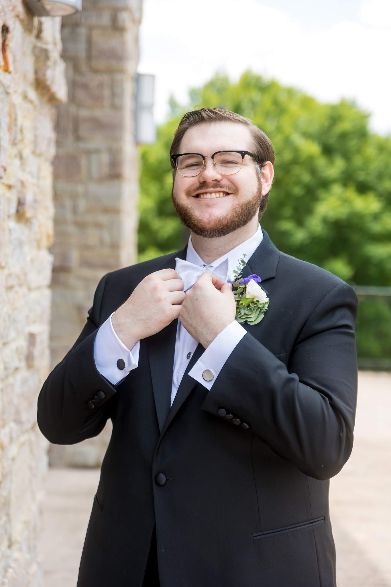 Groom adjusting his bow tie before the wedding at Immaculate Heart of Mary