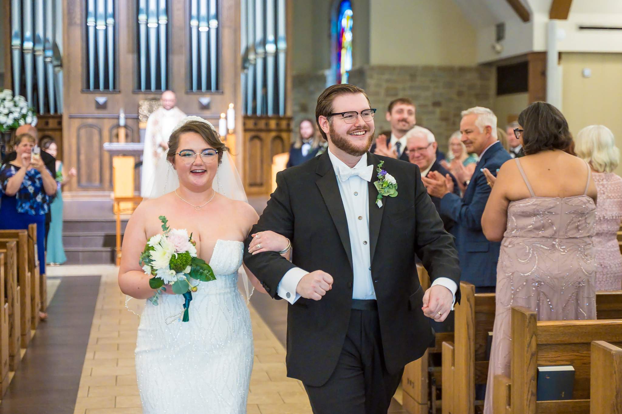 Newlyweds celebrating during the recessional at Immaculate Heart of Mary