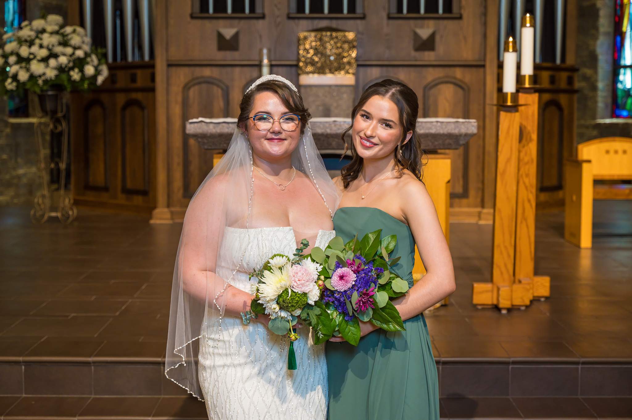 Bride with her bridesmaid at the altar of Immaculate Heart of Mary