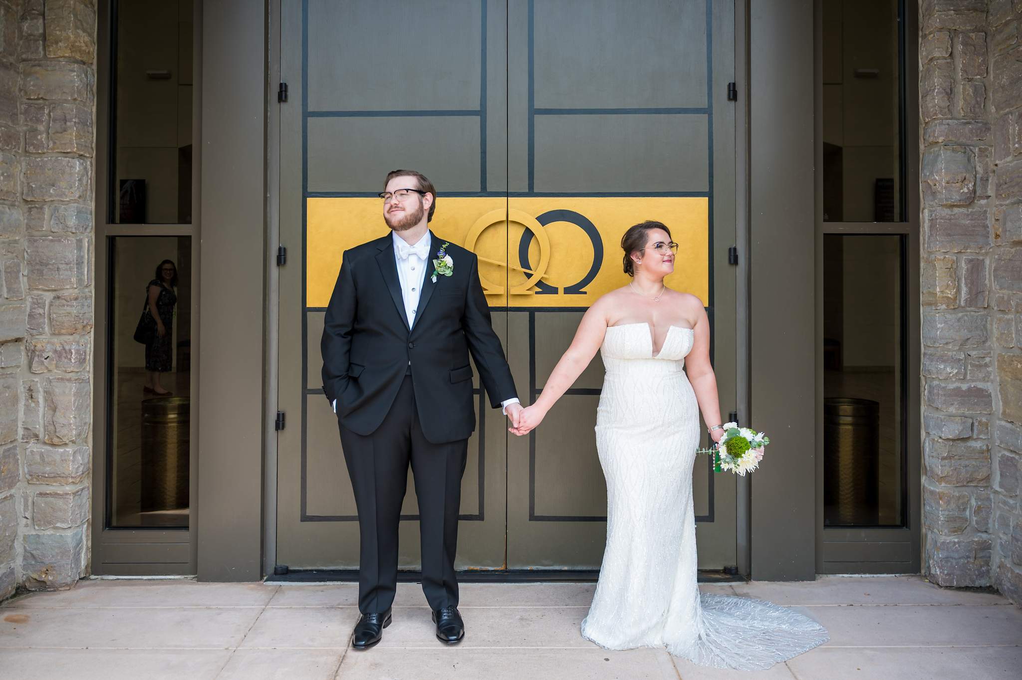 Couple holding hands in front of the gold church doors at Immaculate Heart of Mary