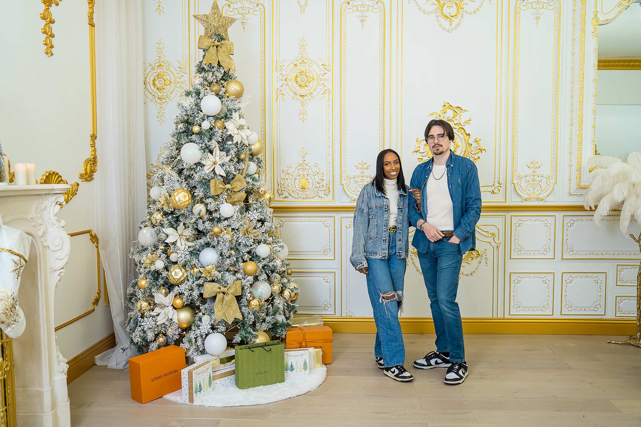 Couple in matching denim beside a Christmas tree in the Palace Set at Luxe Galore