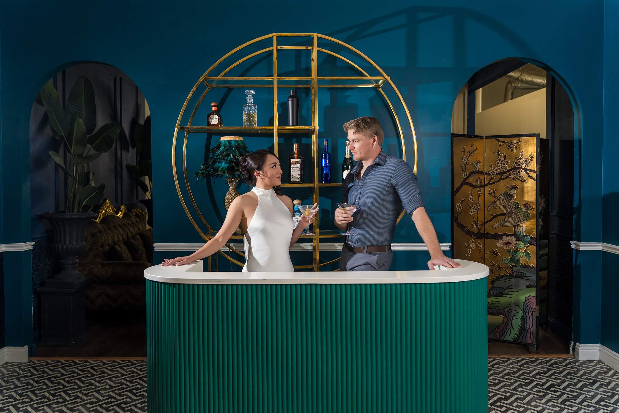 Couple at a teal bar set with gold shelving at Luxe Galore Studios Atlanta