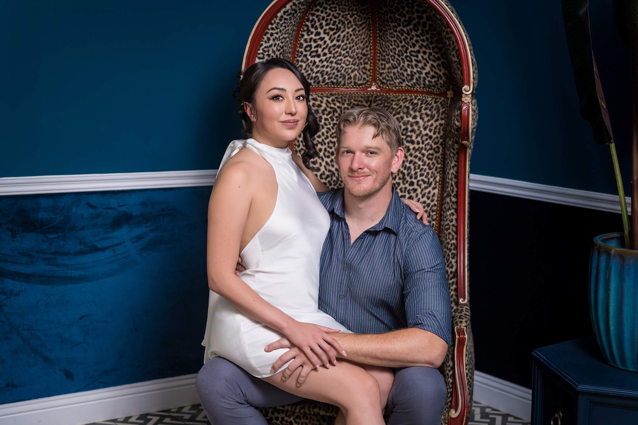 Couple smiling in a rattan chair on a navy set at Luxe Galore Studios Atlanta