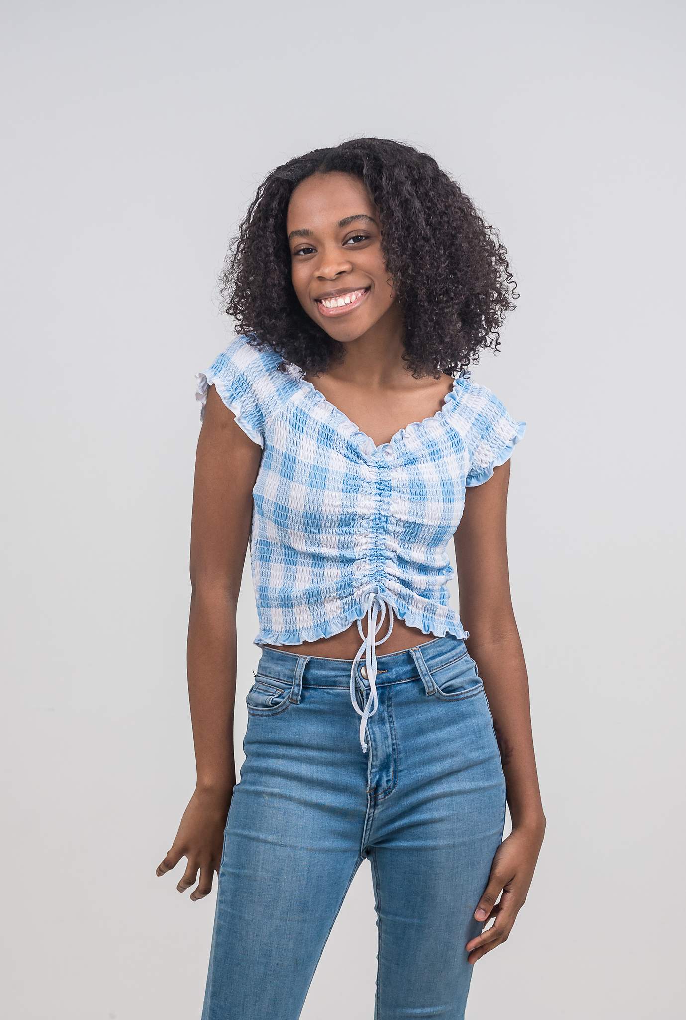 Woman in a gingham top and jeans standing in White Wall Studio Woodstock