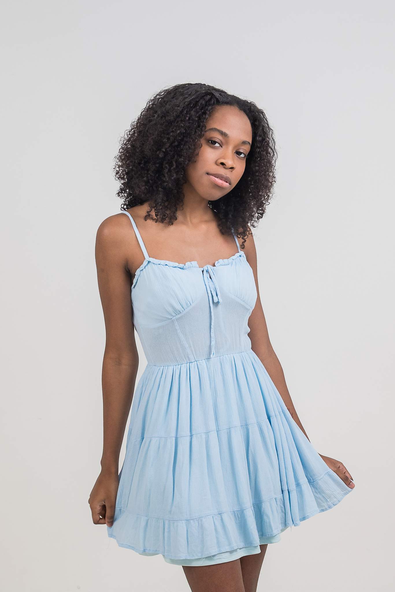 Woman in a light blue sundress standing in a bright studio in Woodstock
