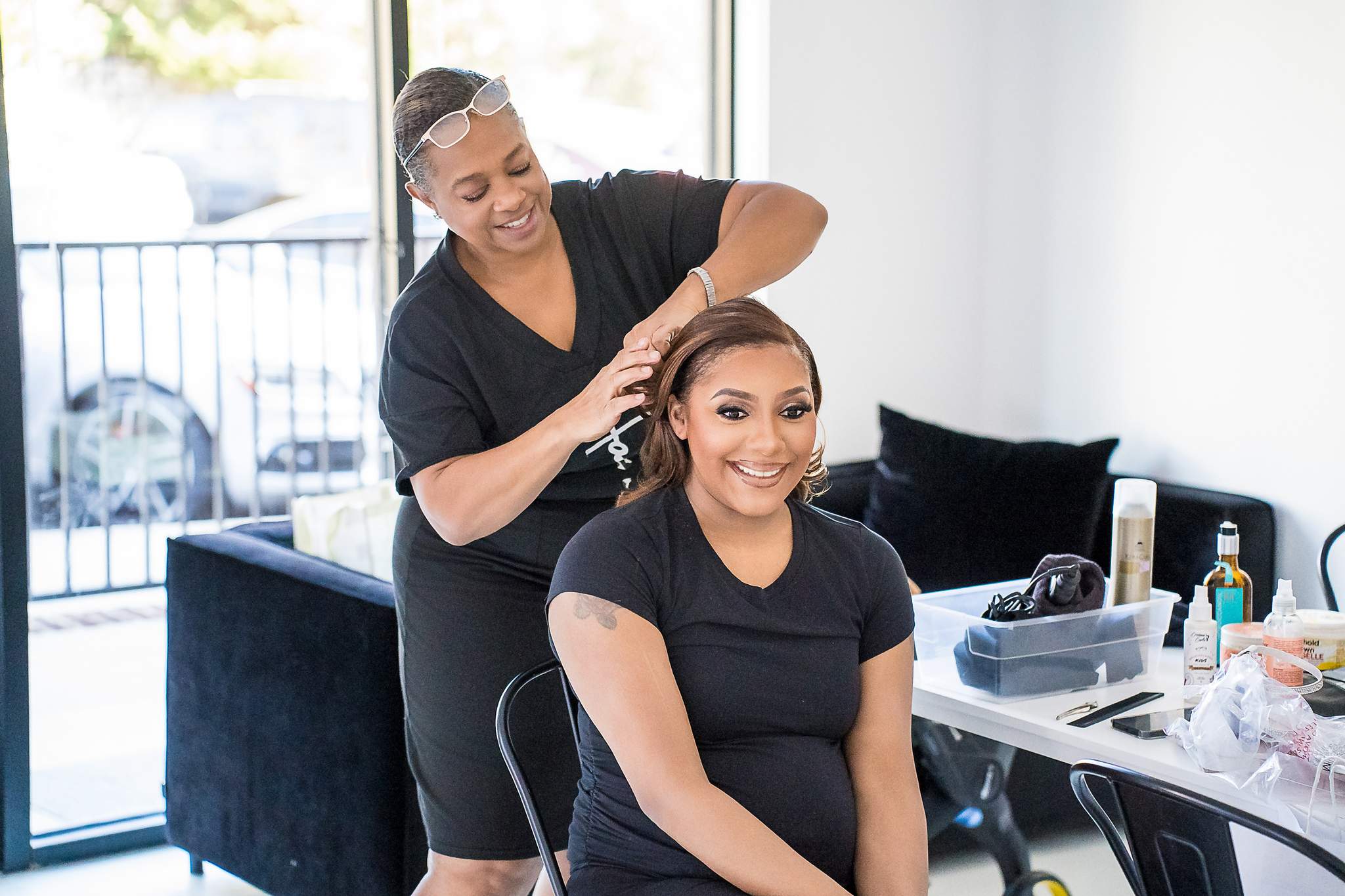 Woman having her hair styled beside the studio windows at White Wall Studio