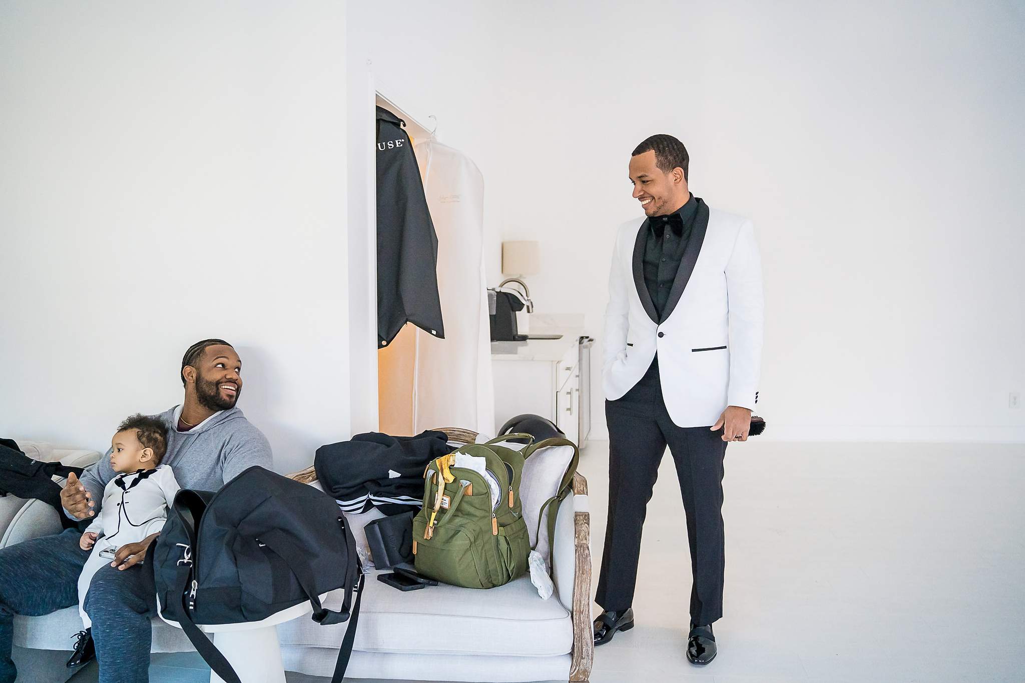 Man in a white tuxedo jacket getting ready in the White Wall Studio lounge