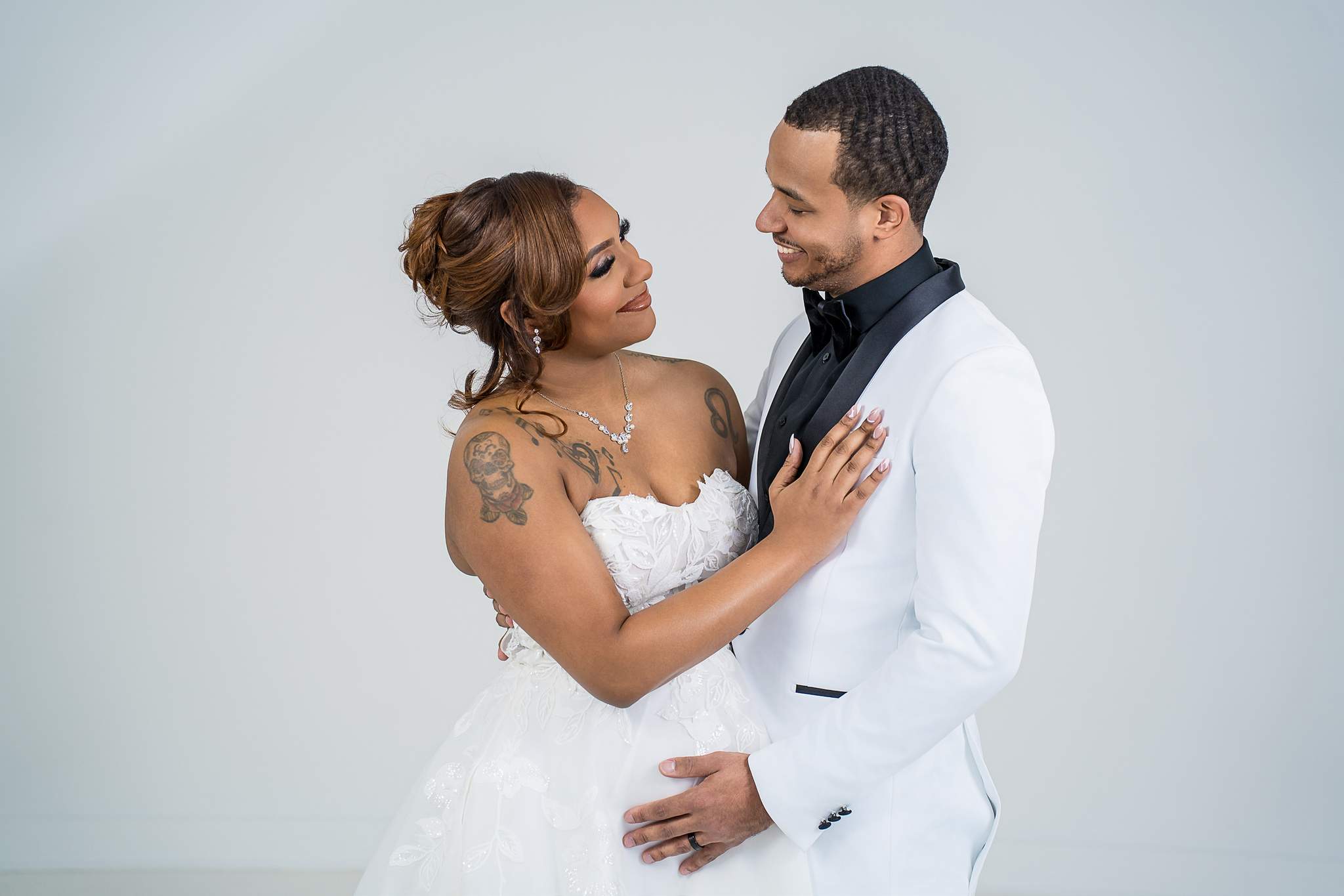 Couple in wedding attire facing each other at White Wall Studio