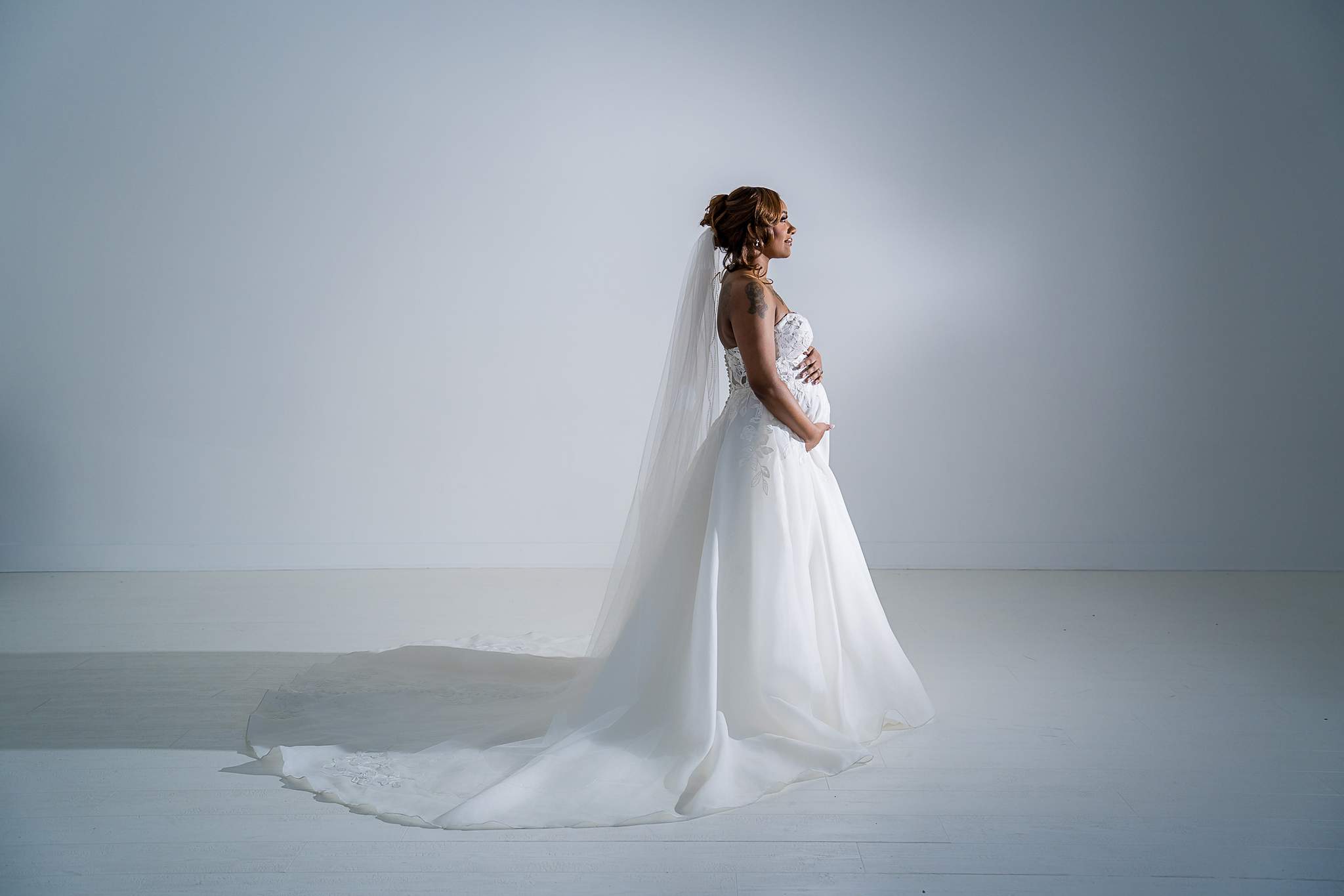 Woman in a wedding gown with a long train in White Wall Studio Woodstock