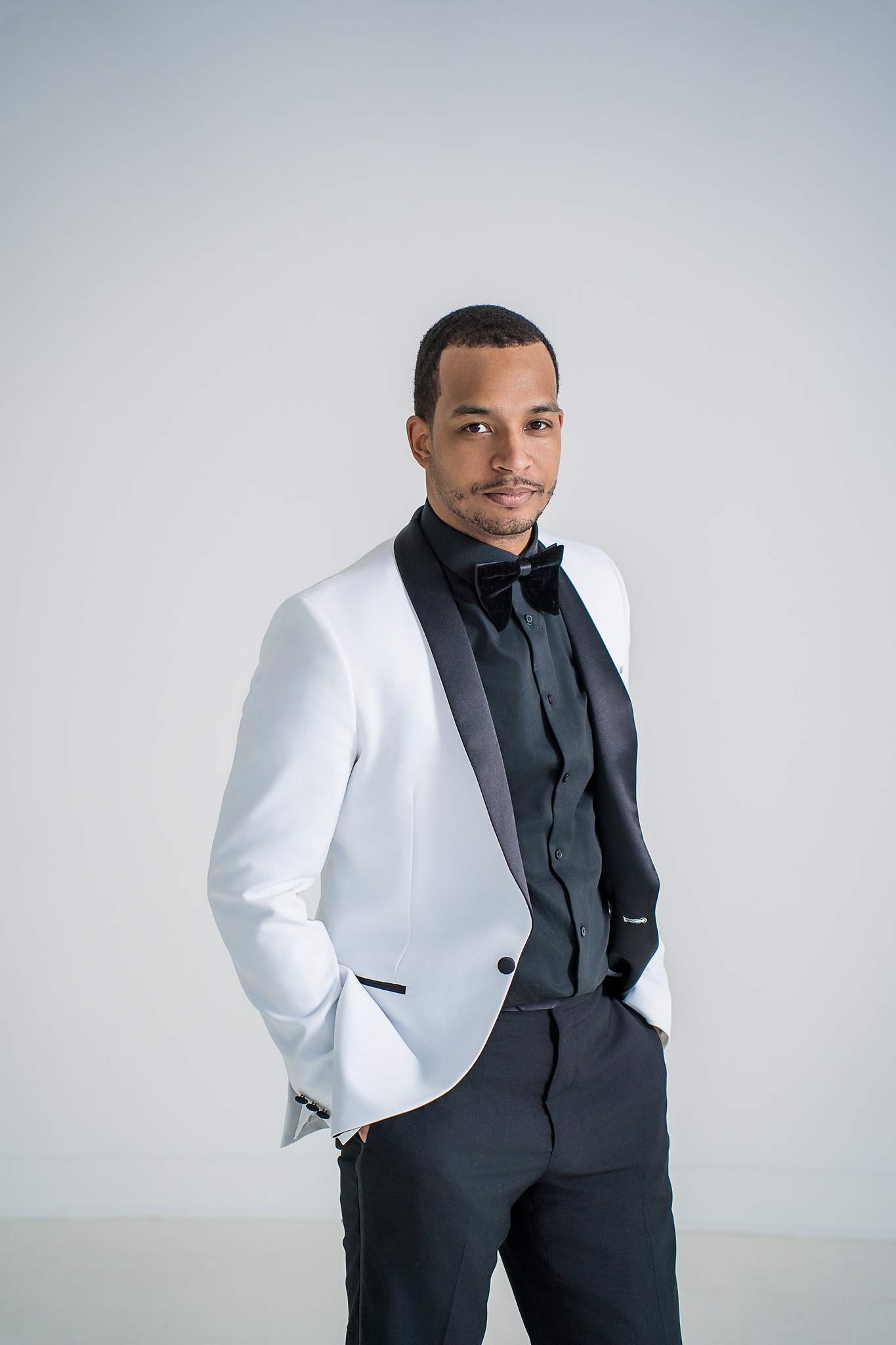 Man in a white tuxedo jacket and bow tie at White Wall Studio