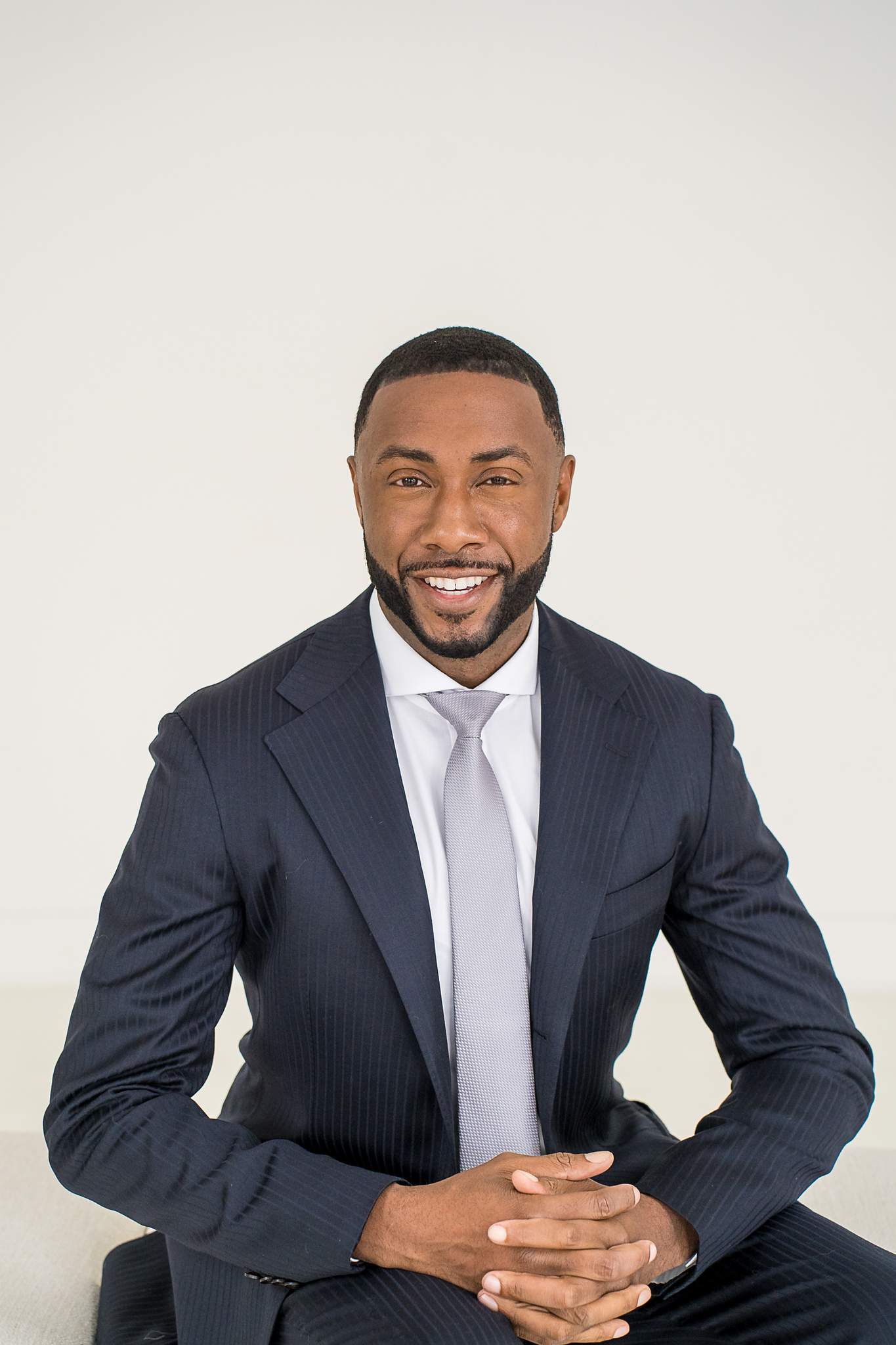 Man in a navy suit seated for a portrait at White Wall Studio Woodstock