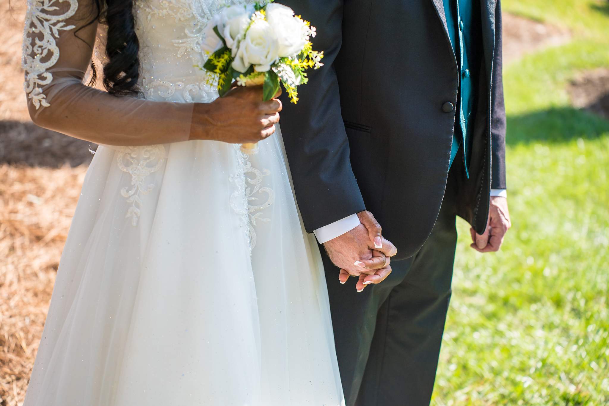 Interracial couple holding hands with a white bouquet at their Atlanta wedding