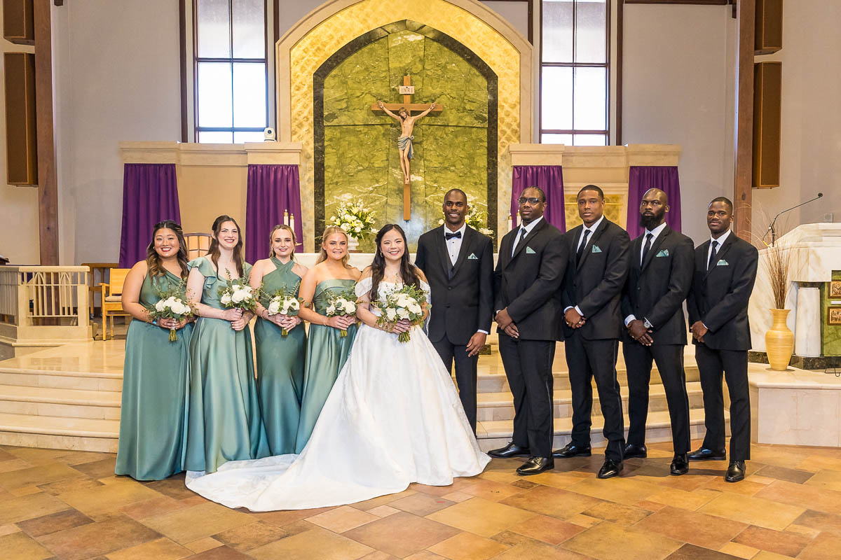 Interracial Wedding Pictures with varied skin tones with large bridal party in dark church