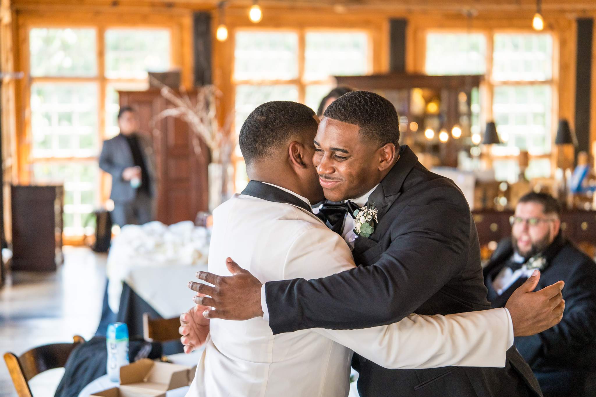 Groom hugging a groomsman while getting ready at Ivy Hall at Roswell Mill