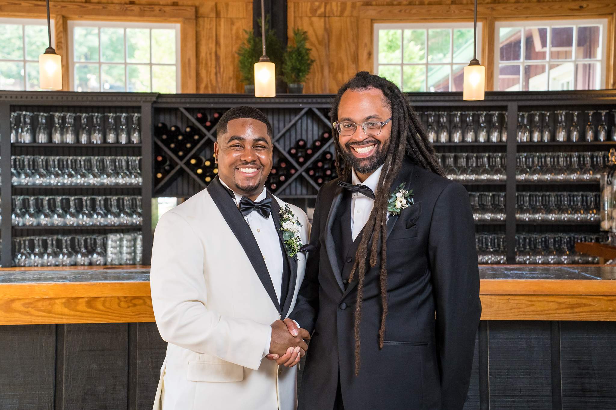 Groom and best man smiling by the bar at Ivy Hall at Roswell Mill