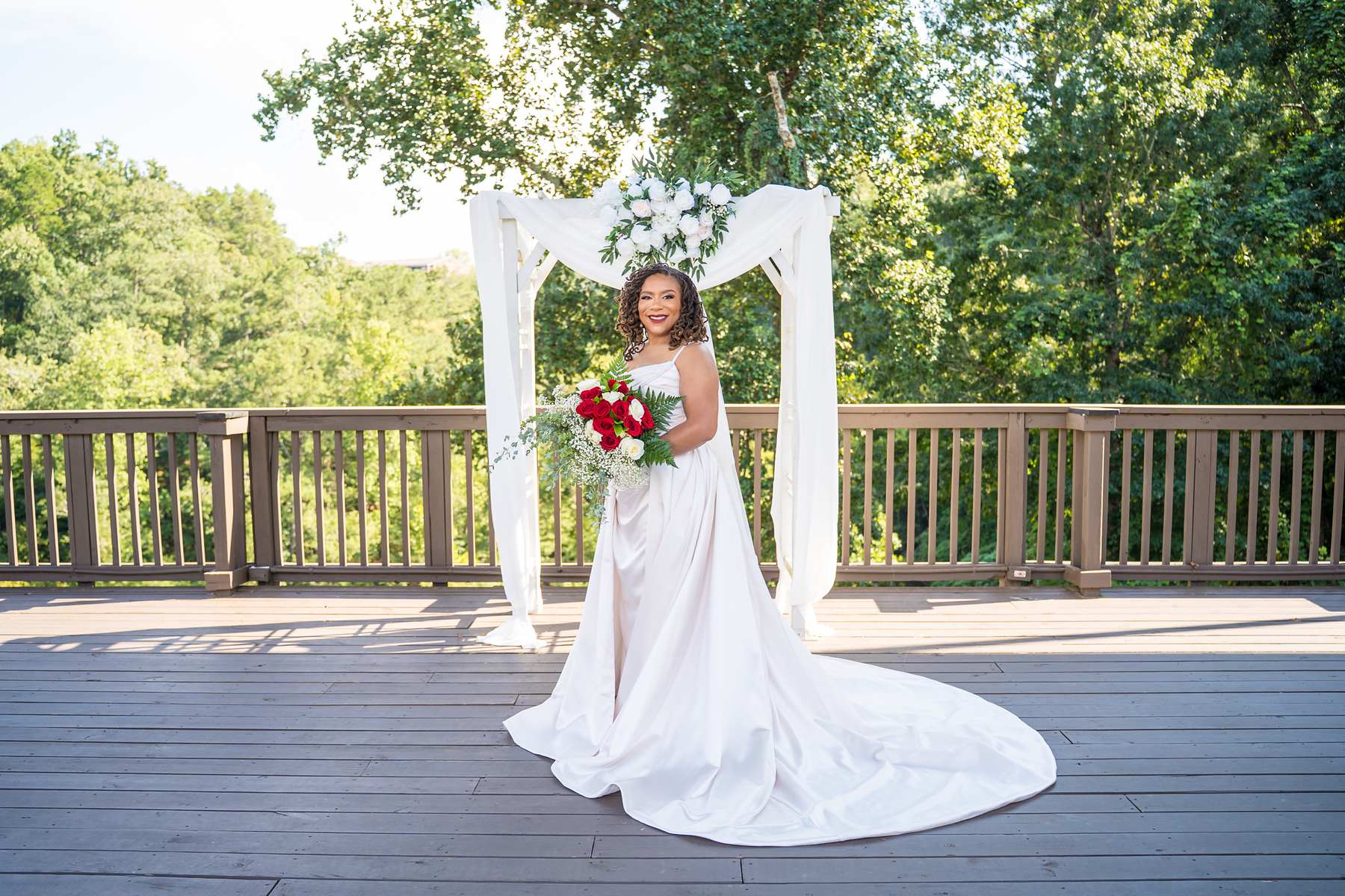 Bride under the floral arbor on the deck at Ivy Hall at Roswell Mill