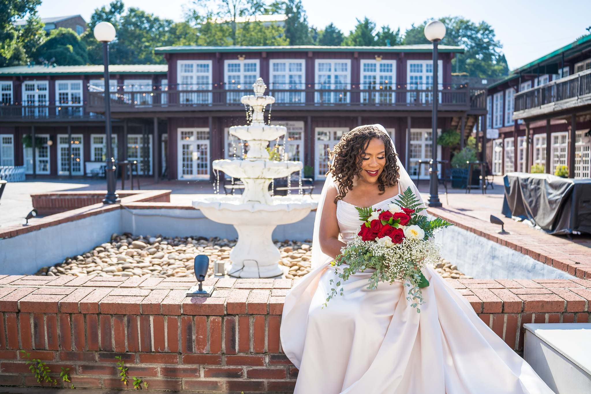Bride seated by the fountain in the Roswell Mill courtyard