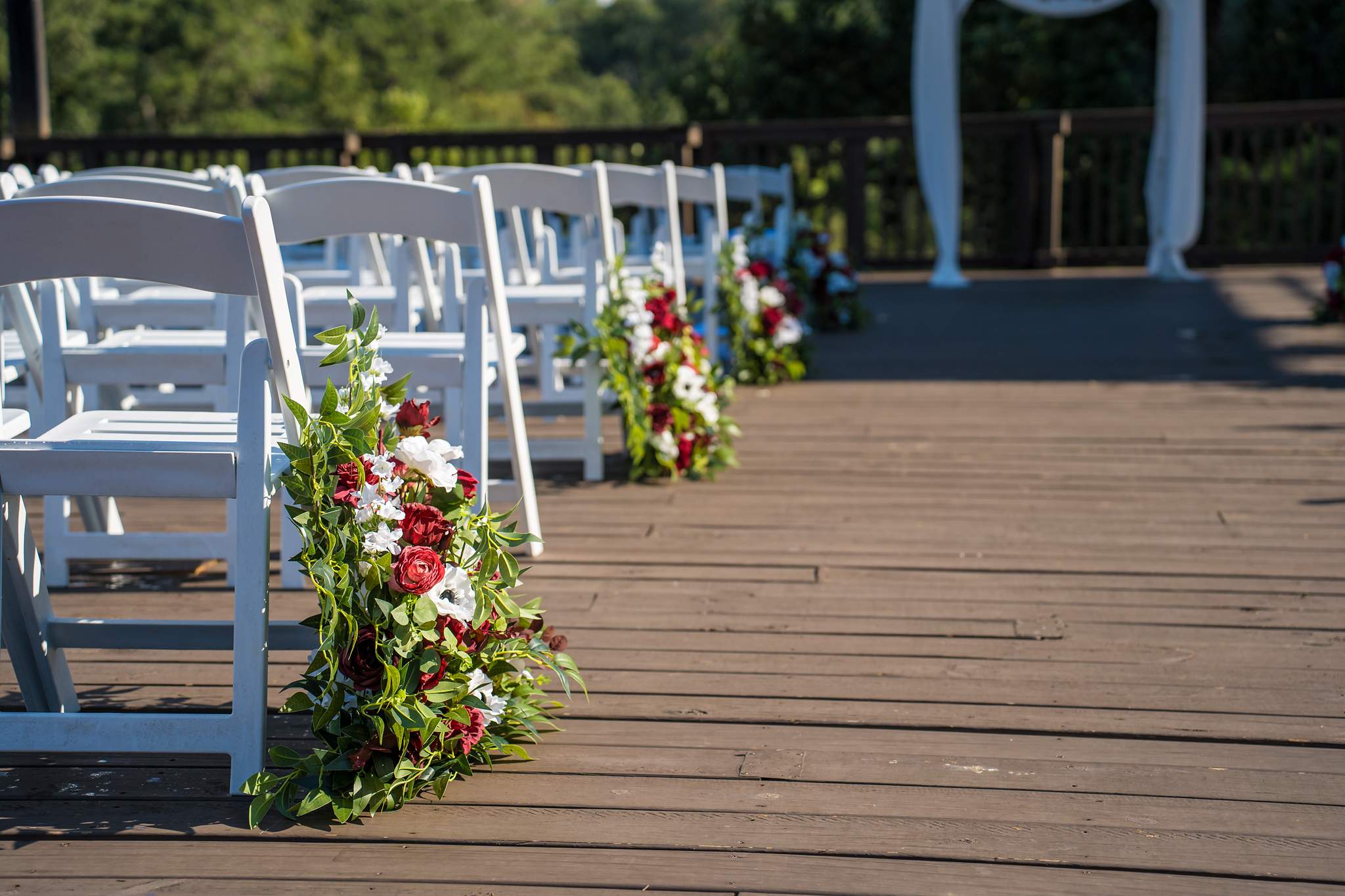 Ceremony chairs and floral aisle arrangements on the deck at Ivy Hall at Roswell Mill