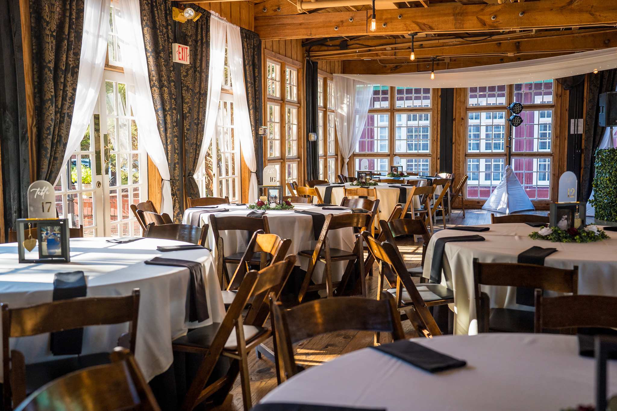 Reception room with wood beams and tall windows at Ivy Hall at Roswell Mill