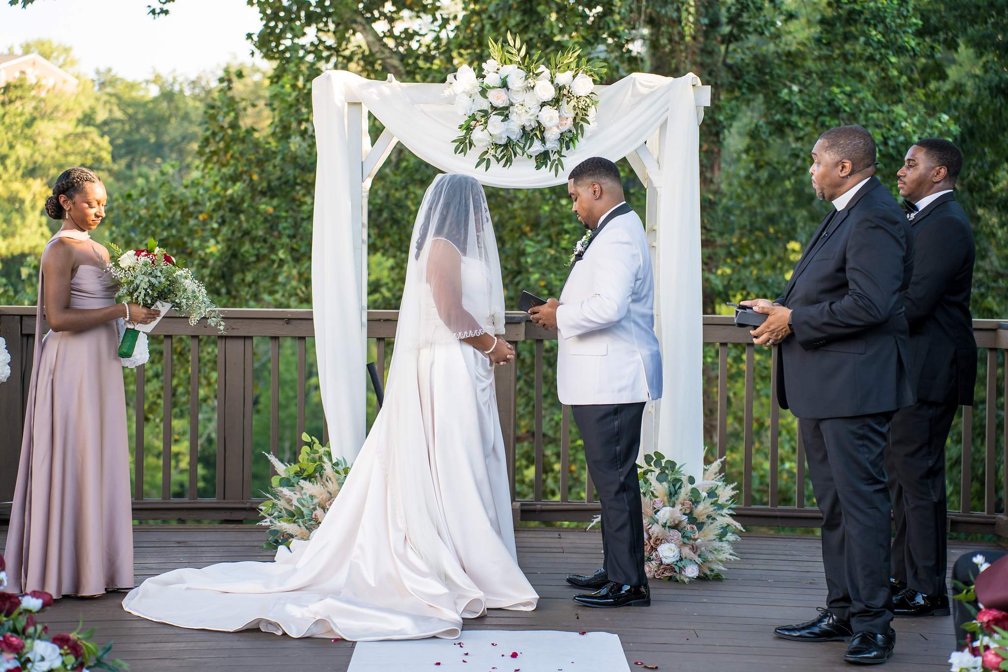 Couple facing each other under the arbor during their Ivy Hall at Roswell Mill ceremony