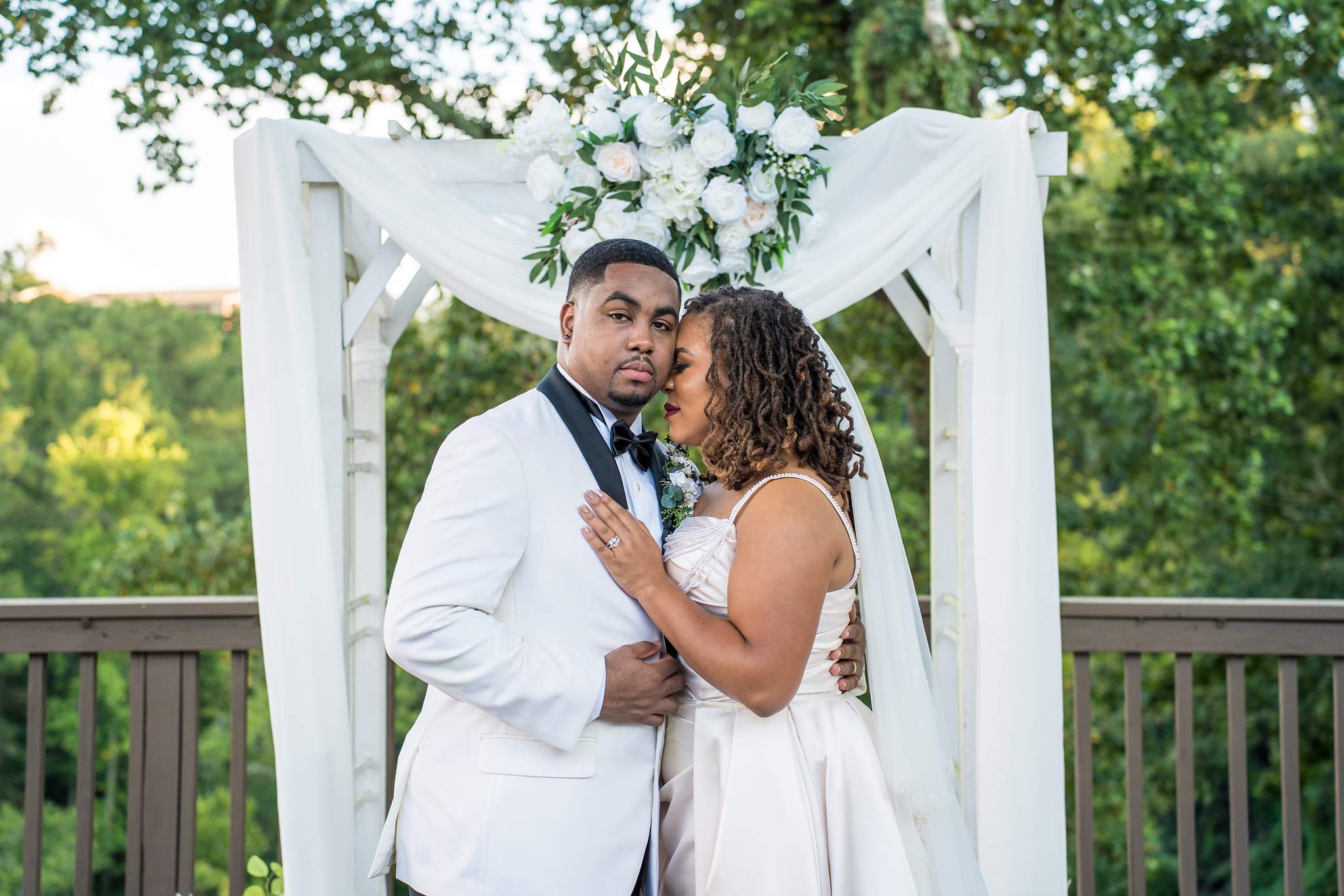 Couple sharing a moment under the floral arbor at Ivy Hall at Roswell Mill