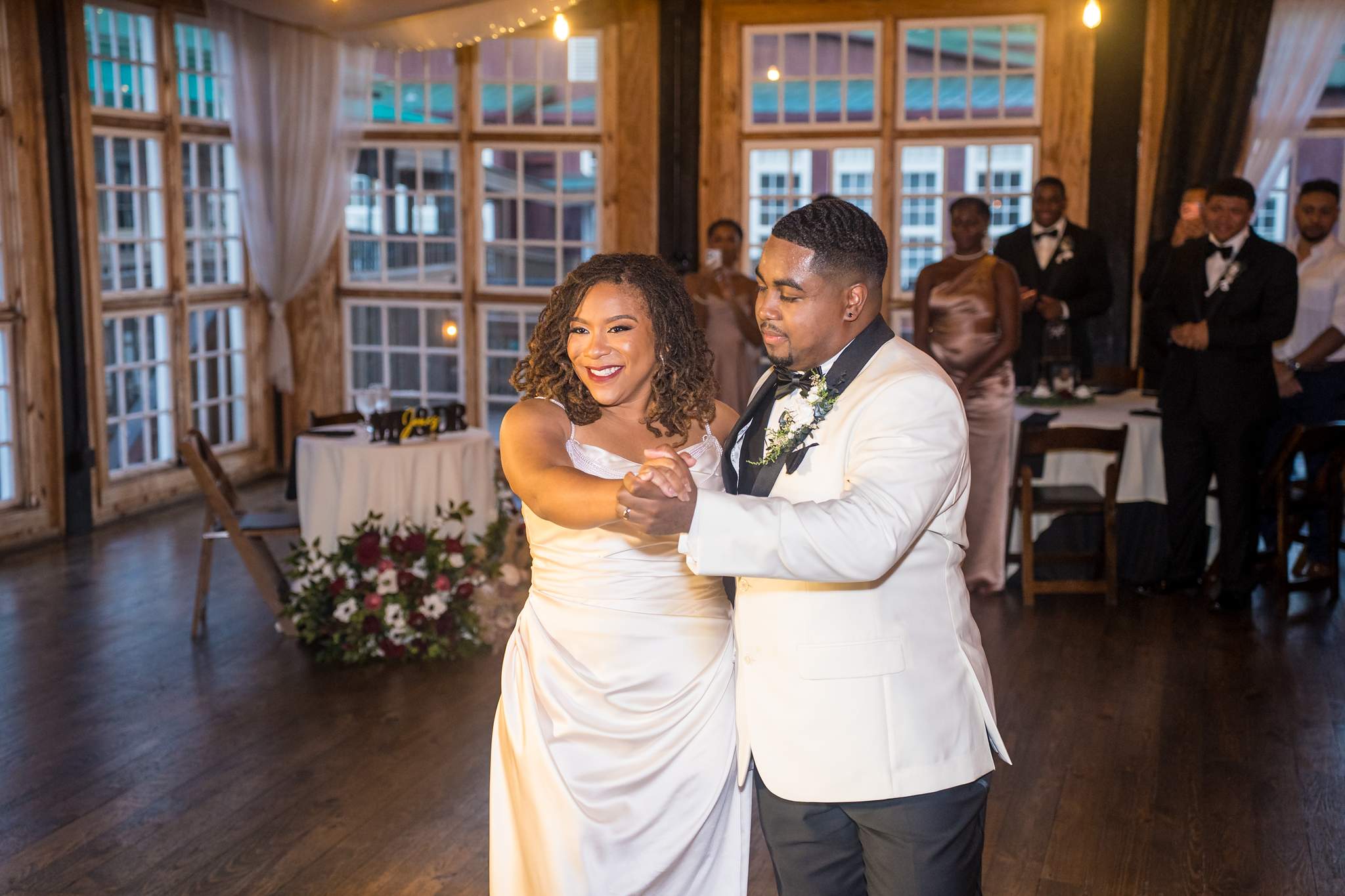 Couple dancing in the warm light of the Ivy Hall at Roswell Mill reception room