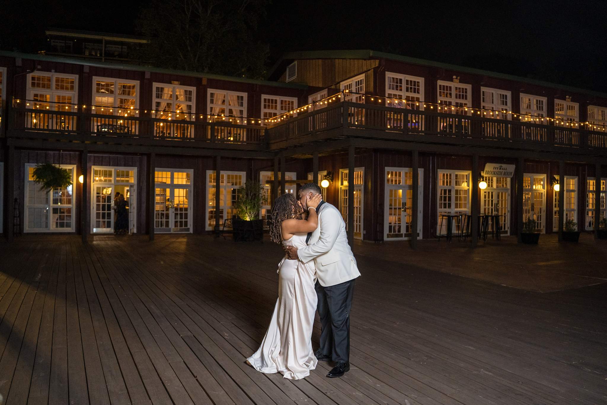 Couple embracing on the deck at night at Ivy Hall at Roswell Mill