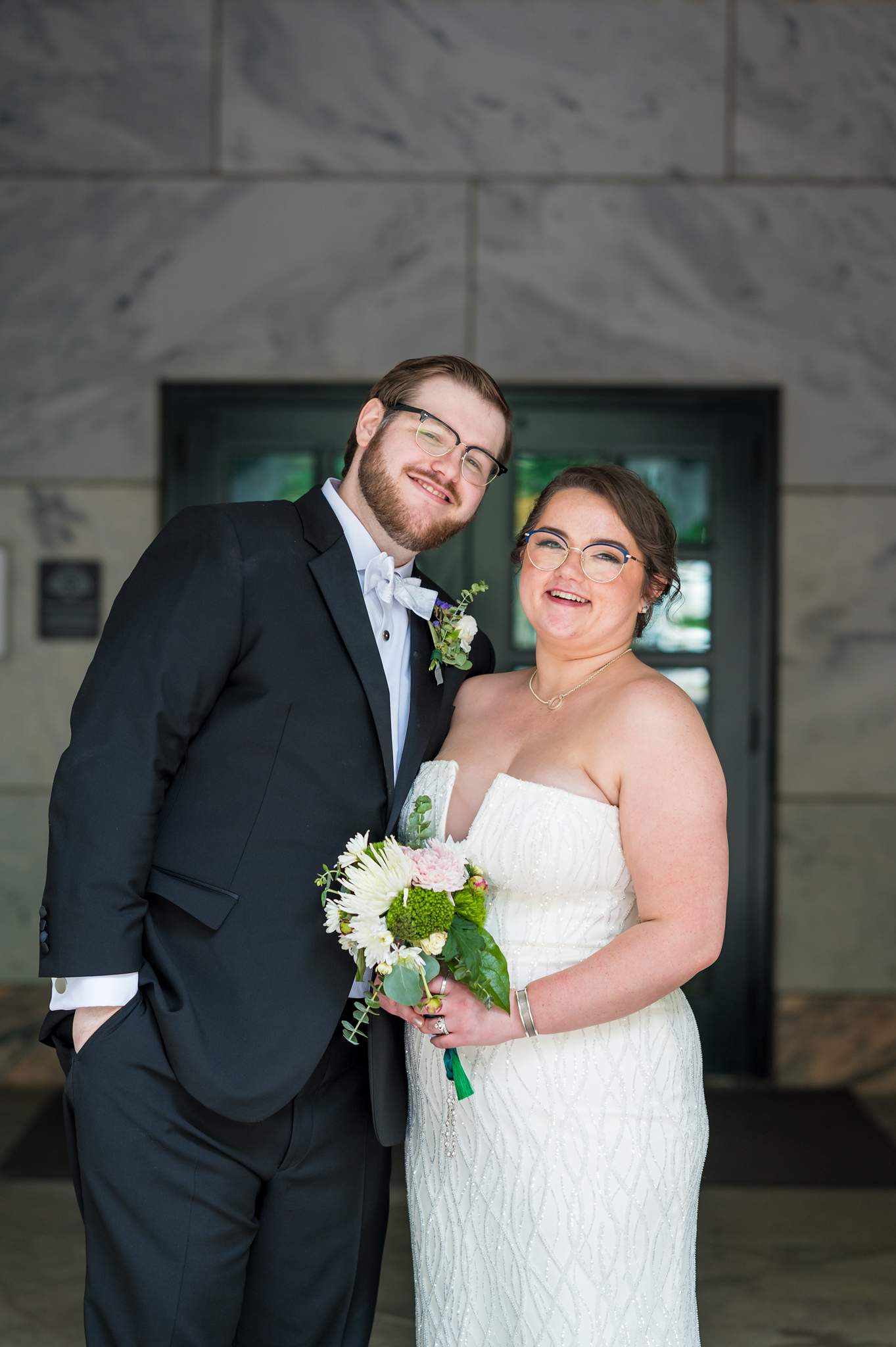 Couple portrait against the marble wall of the Michael C. Carlos Museum