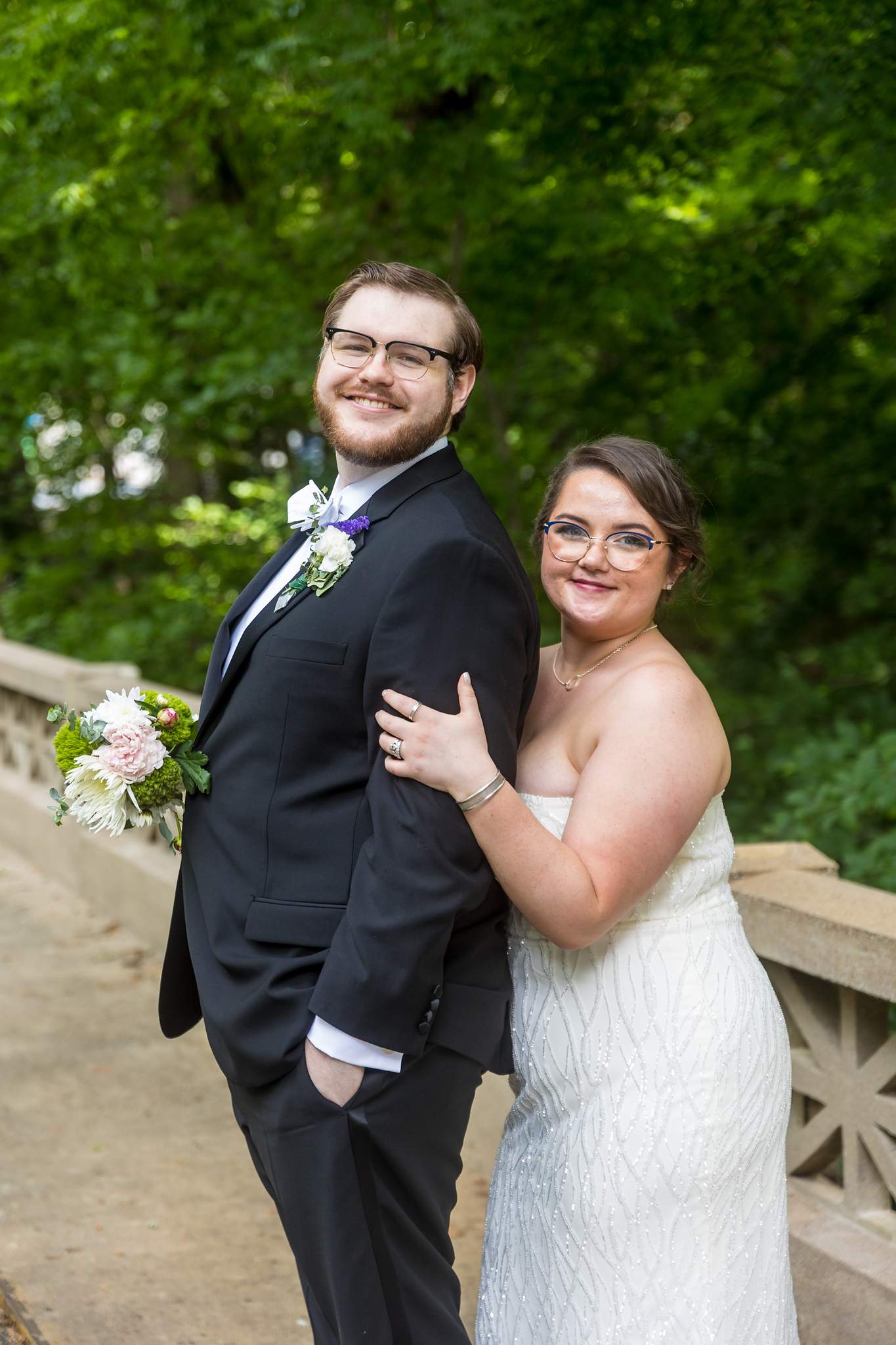 Couple portrait by a stone railing with greenery at Emory