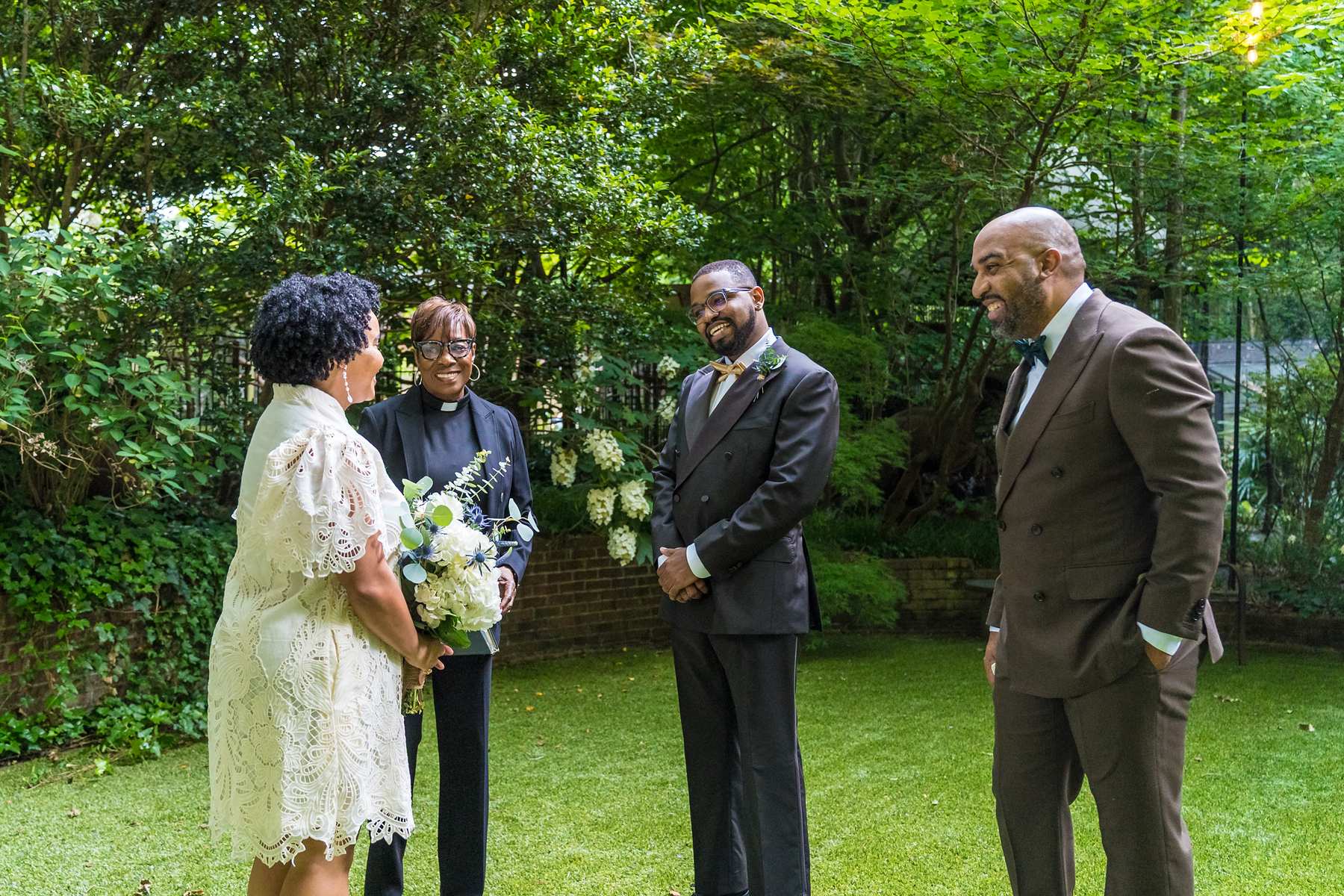 Micro wedding ceremony in a garden in Atlanta with the couple facing their officiant