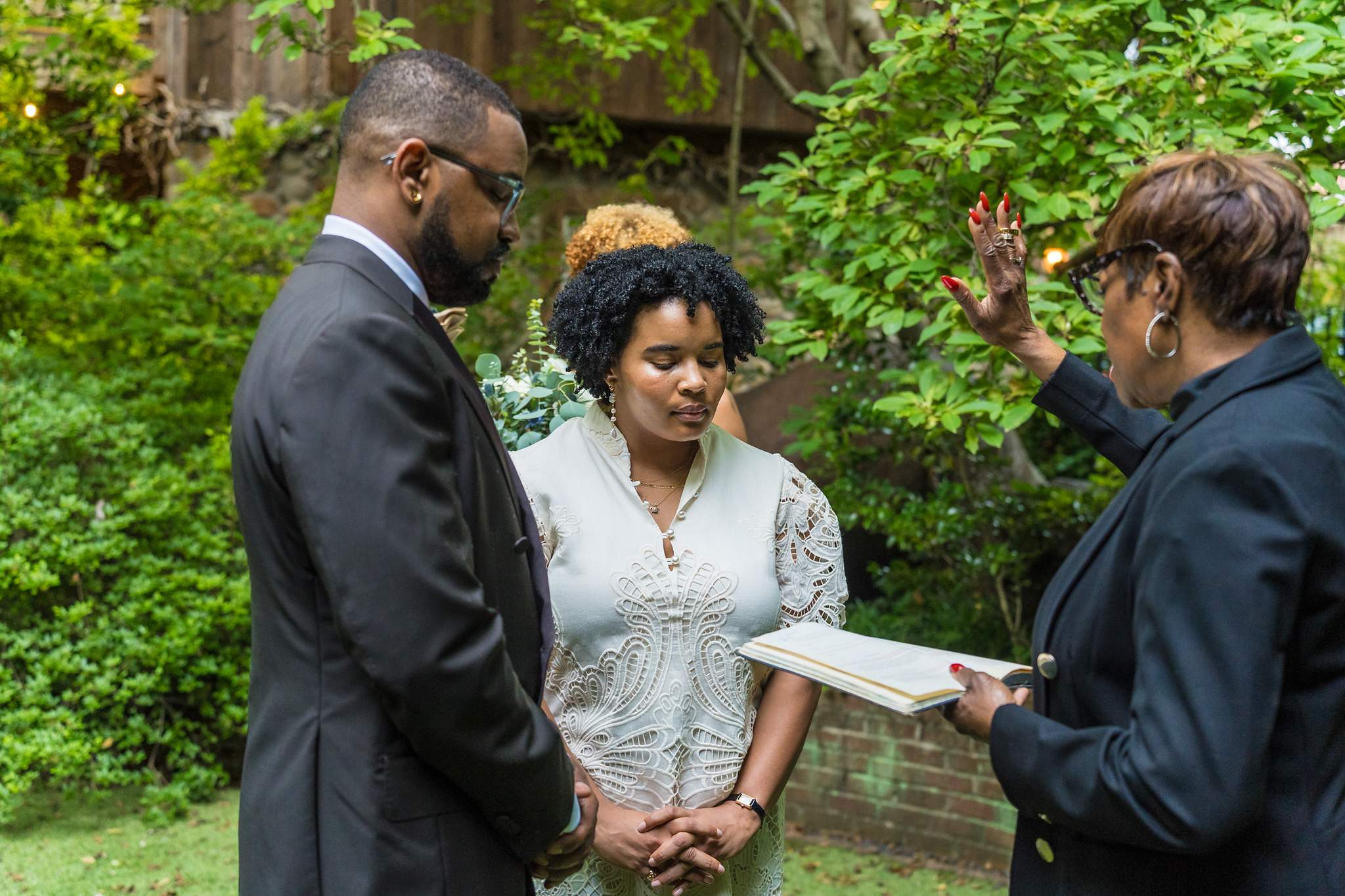 Officiant blessing the couple during a small garden wedding ceremony in Atlanta