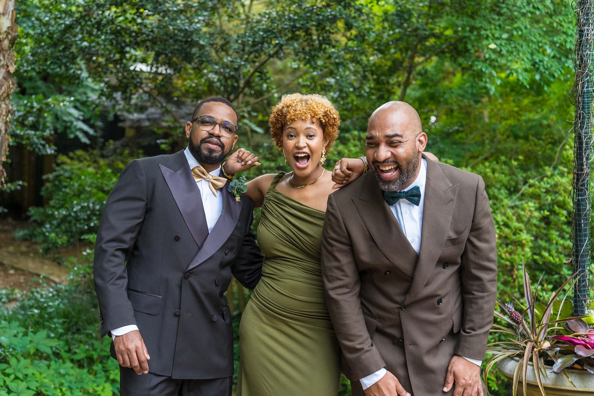 Groom laughing with friends during portraits after an intimate ceremony