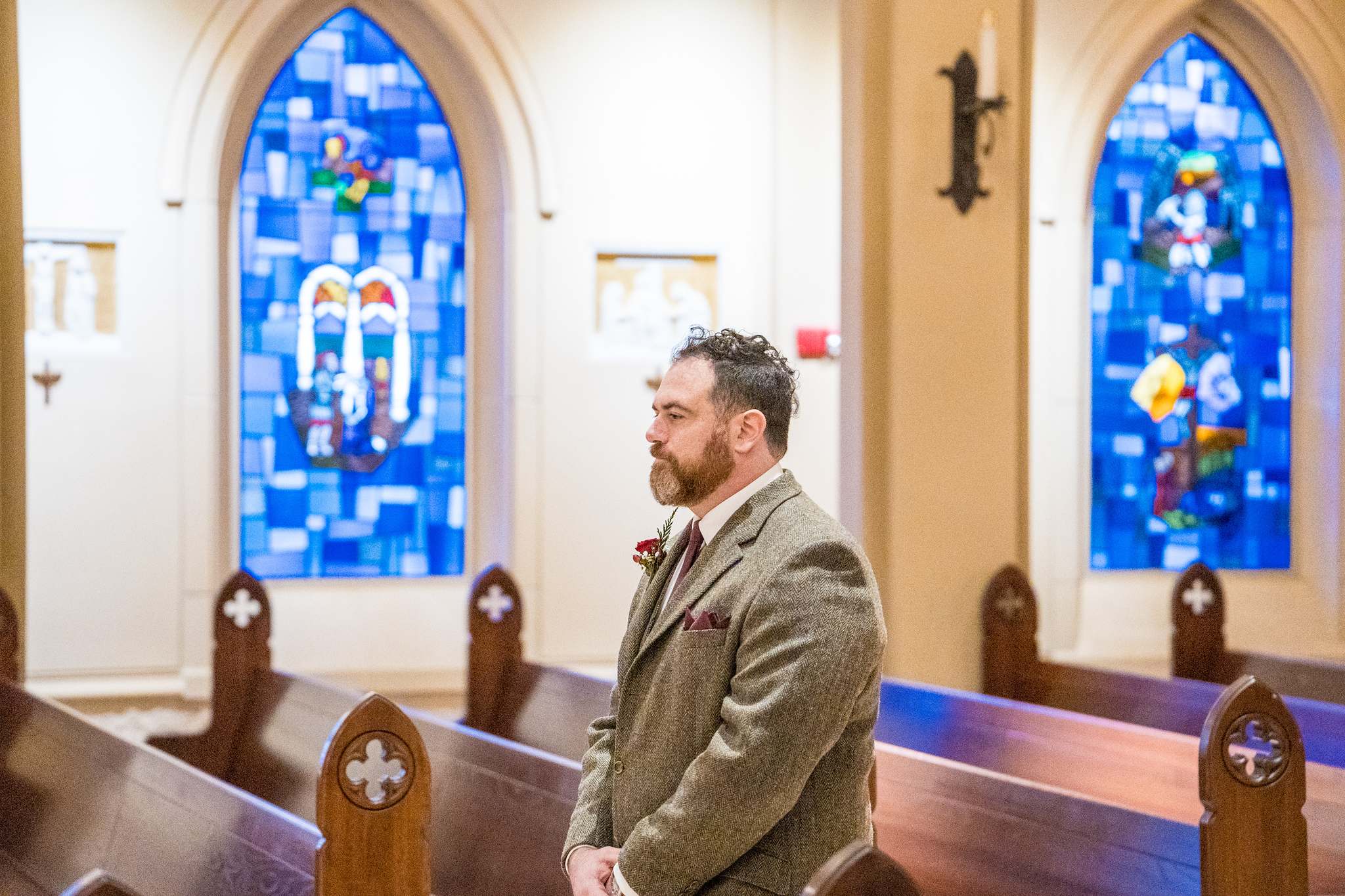Groom waiting near the stained glass windows at Our Lady of the Assumption Catholic Church in Atlanta