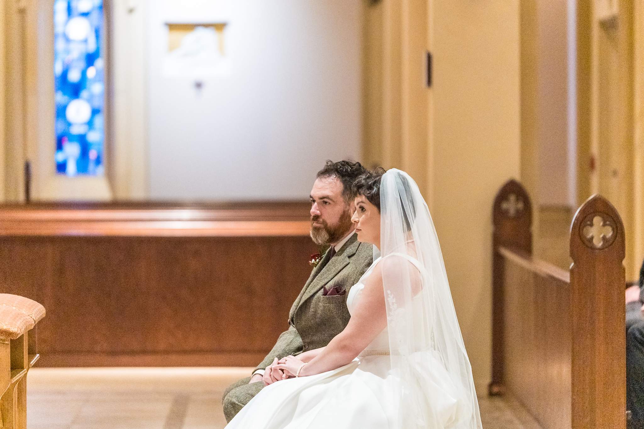 Couple seated at the front of the sanctuary during a Catholic wedding Mass