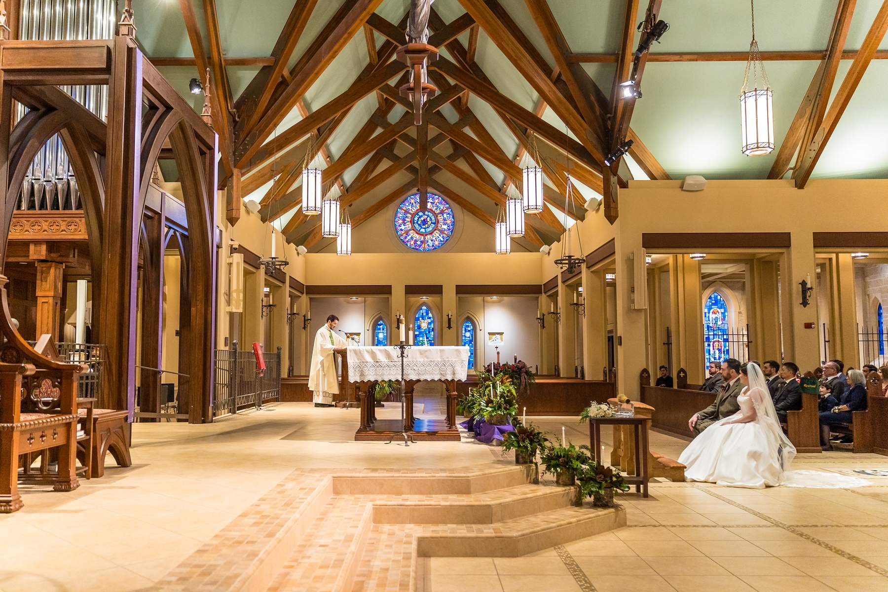 Wide view of the sanctuary and wood ceiling during a wedding at Our Lady of the Assumption