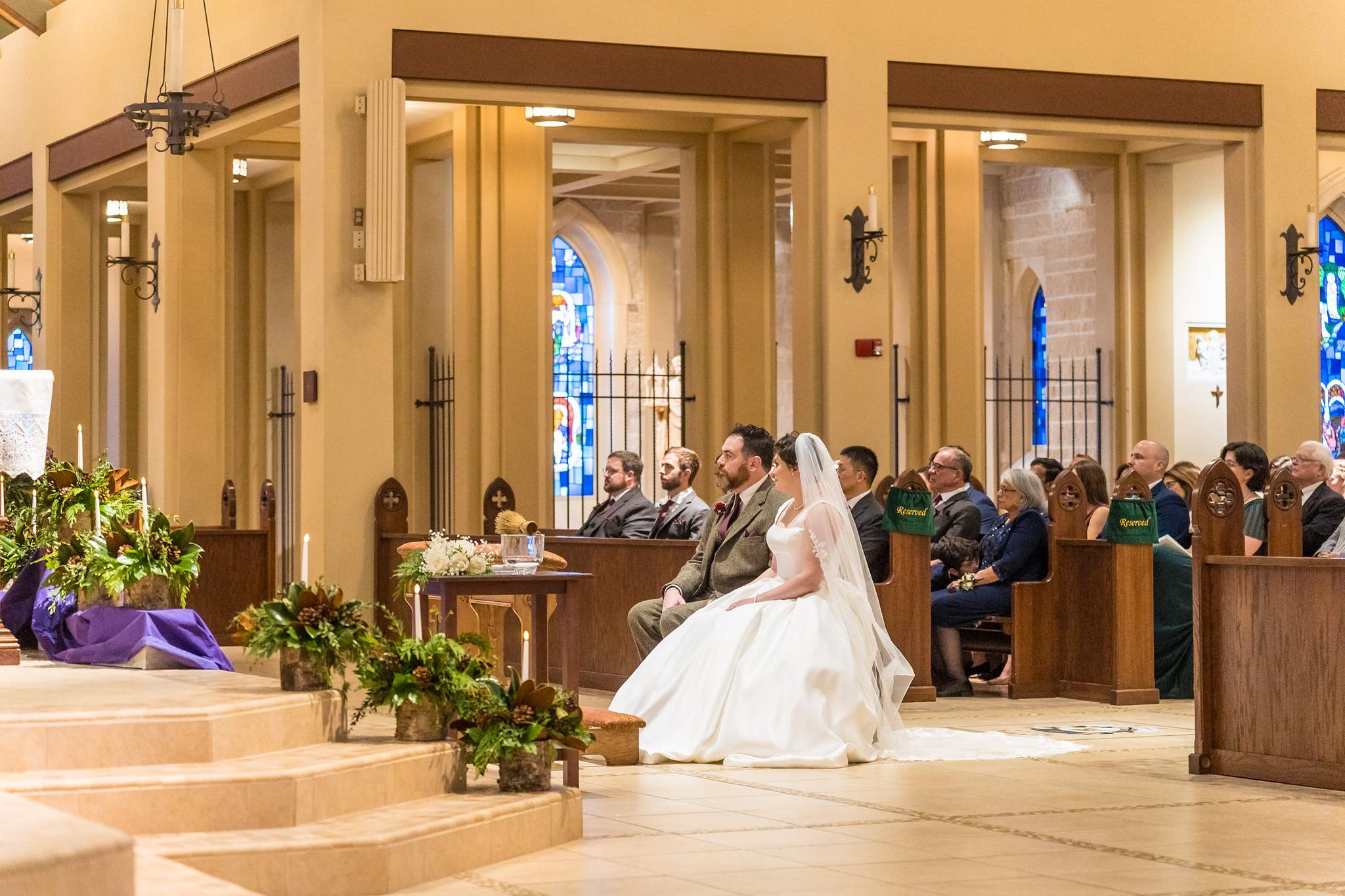 Bride and groom kneeling at the altar during their wedding at Our Lady of the Assumption