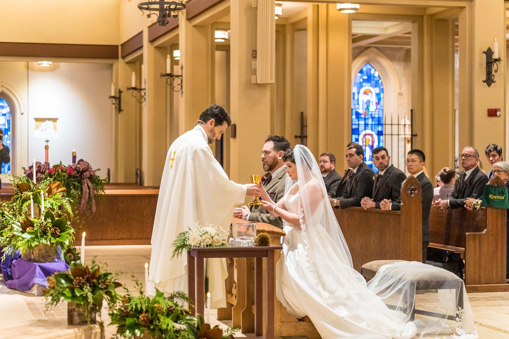 Priest offering communion to the couple during their wedding Mass